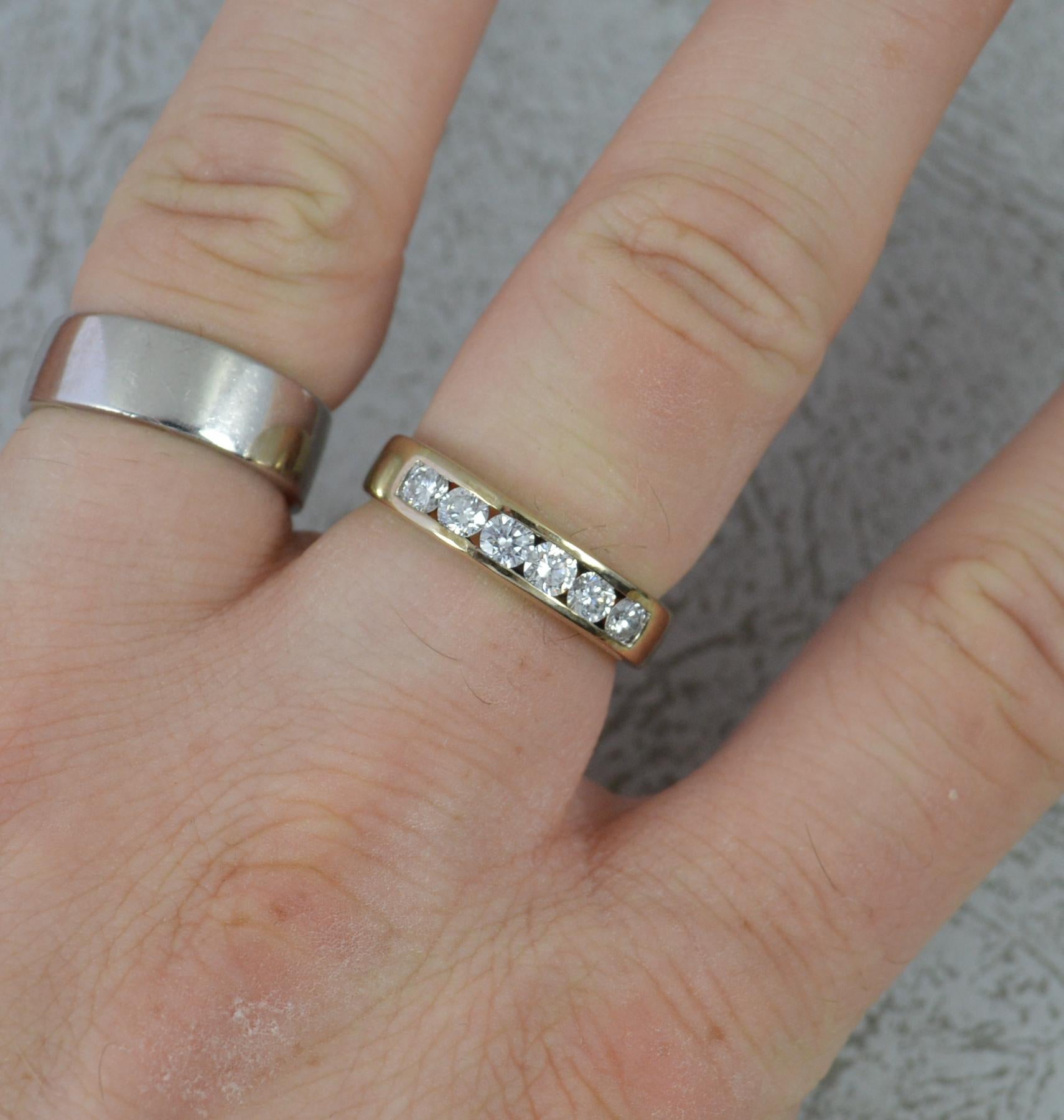A fine half eternity stack ring.
Solid 18 carat yellow gold shank with an engraved finish to each side of the white gold head.
Set with seven natural princess cut diamonds to total 0.6cts, vs clarity, g-h colour.
17mm spread of stones. 4mm wide band