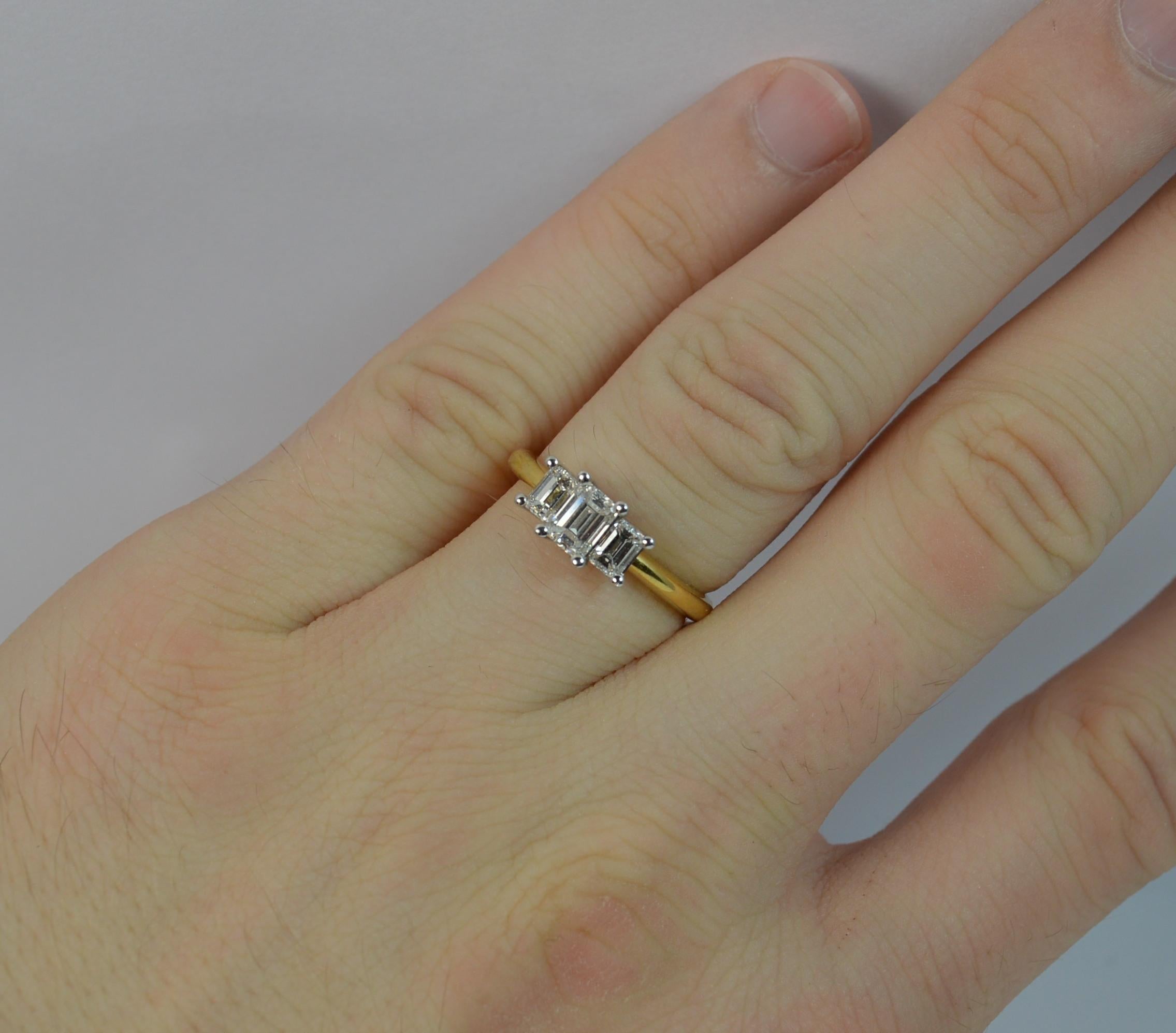 
An 18ct Gold and Diamond three stone ring.

Designed with three natural emerald cut diamonds to total 0.91 carats. The diamonds are of VS clarity and E-F colour, very clean, white and sparkly. All mounted in 18ct white gold claws.

Set onto a solid
