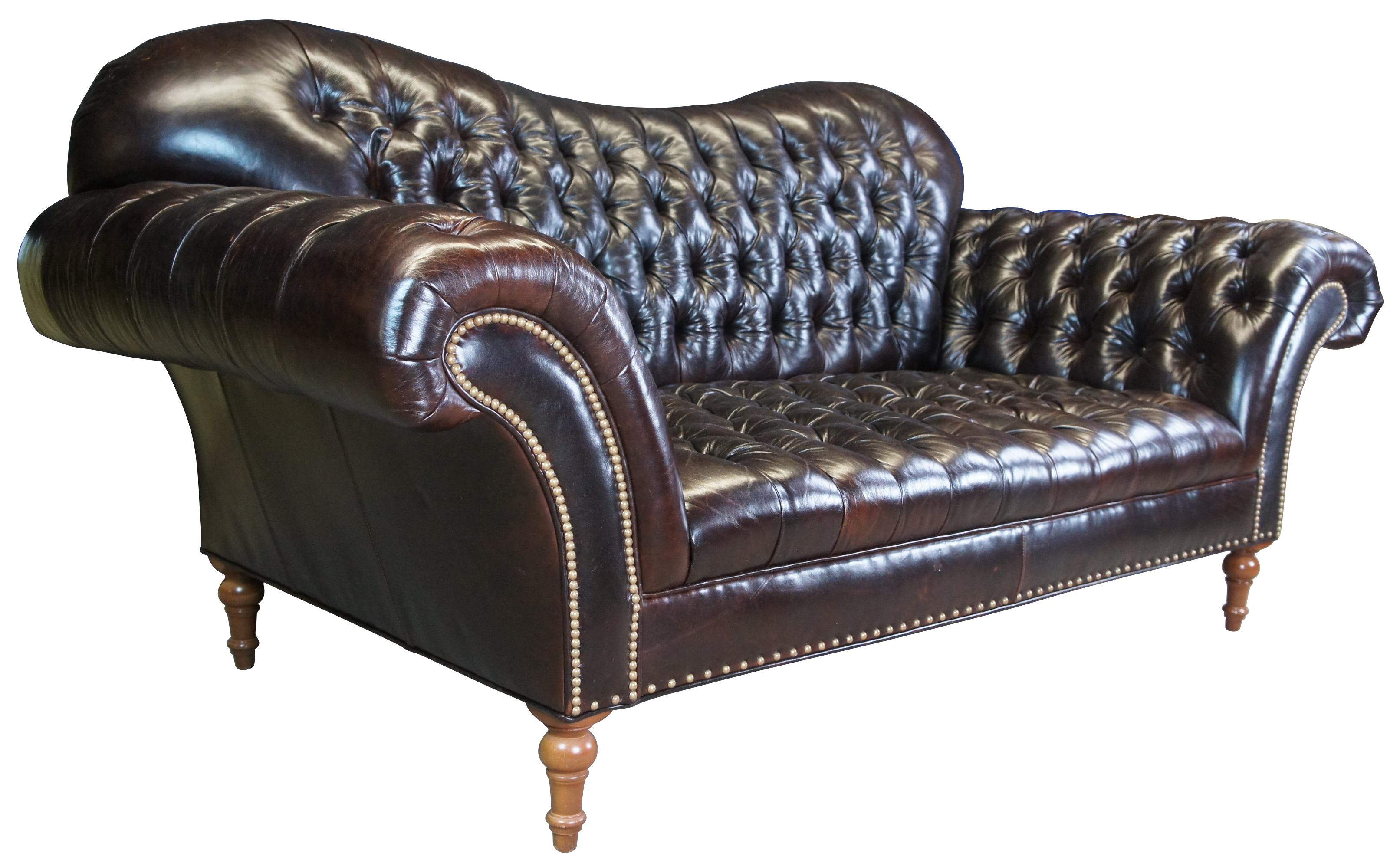 Vintage Arhaus Arabelle club fitted sofa, couch or love seat. Upholstered in a dark brown tufted leather featuring Chesterfield form with flared arms, a camelback and nailhead trim. The sofa is supported by maple turned feet.
