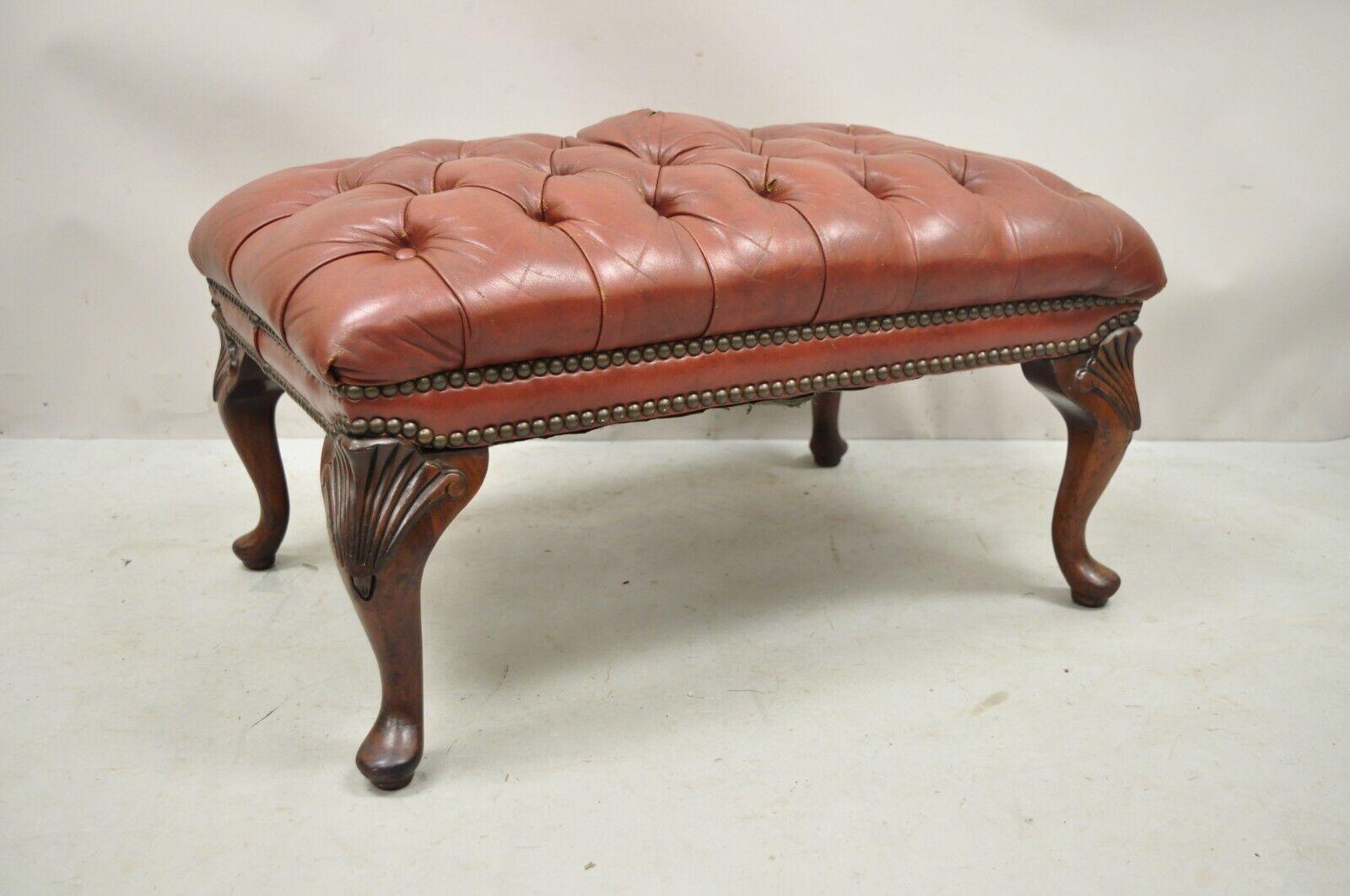 Vintage brown leather English Chesterfield Queen Anne style Tufted Ottoman Footstool. Item features shell carved knees, button tufted brown leather upholstery, solid wood frame, beautiful wood grain, nicely carved details, very nice antique item.
