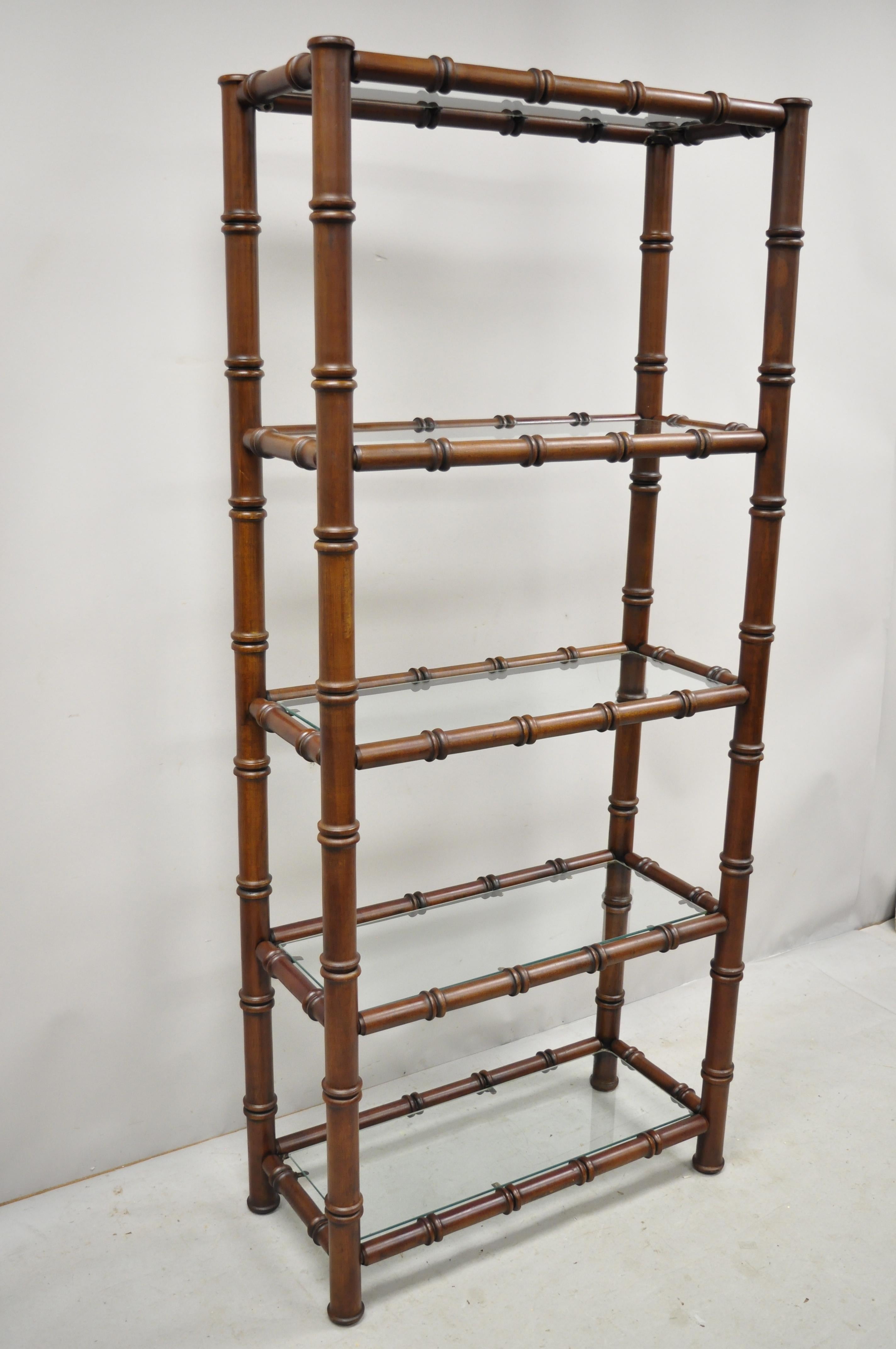 Vintage faux bamboo Hollywood Regency Chinese Chippendale wood and glass étagère stand. Item features a faux bamboo carved wood frame, beautiful wood grain, 5 glass shelves, great style and form, circa mid-20th century. Measurements: 72.5