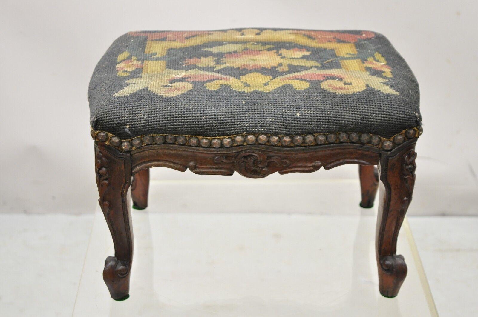 Vintage French Country Louis XV style Carved Walnut Needlepoint Footstool Ottoman. Item features a carved walnut base, floral needlepoint upholstery, very nice antique item, great style and form. Circa Early 1900s. Measurements: 9.5