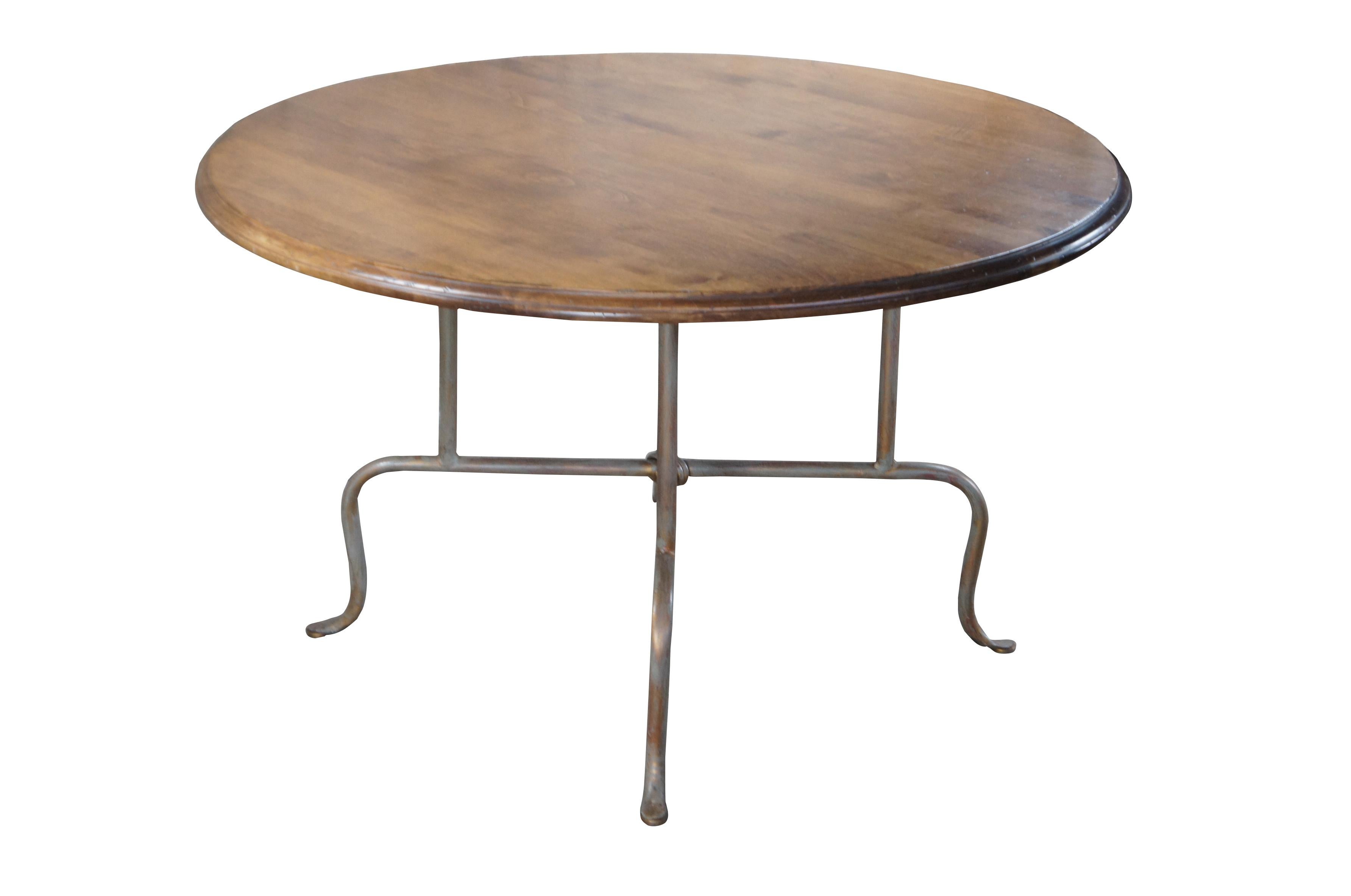 Late 20th century French inspired bistro, dining or breakfast table.  Features a round birch top over iron birdcage style base connected by an X stretcher over cabriole legs.

Dimensions: 
48