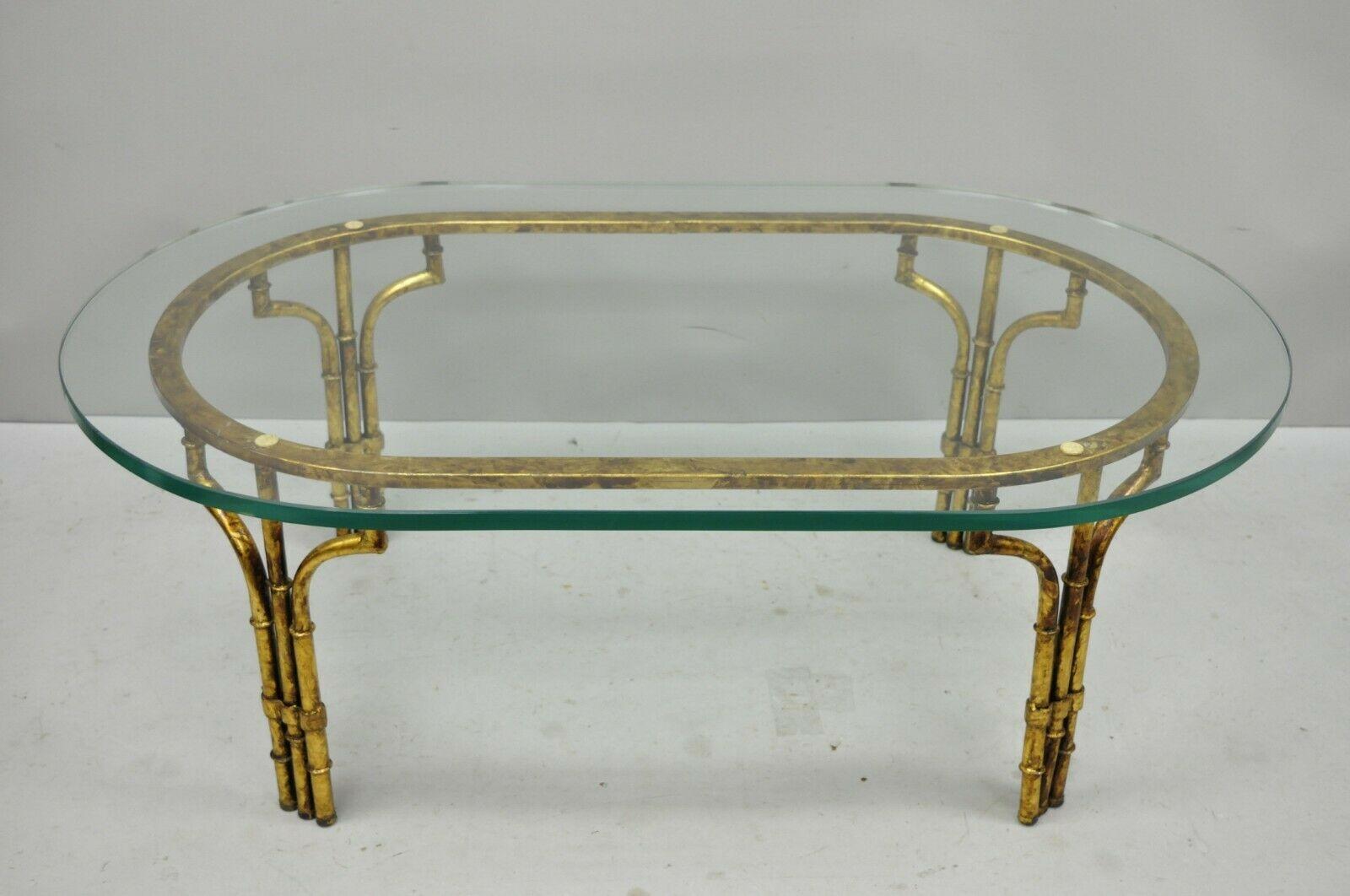 Vintage Italian Hollywood Regency faux bamboo oval glass gold gilt iron coffee table. Item features gold gilt iron frame, thick oval glass top, quality Italian craftsmanship, circa mid-20th century. Measurements: 16.5