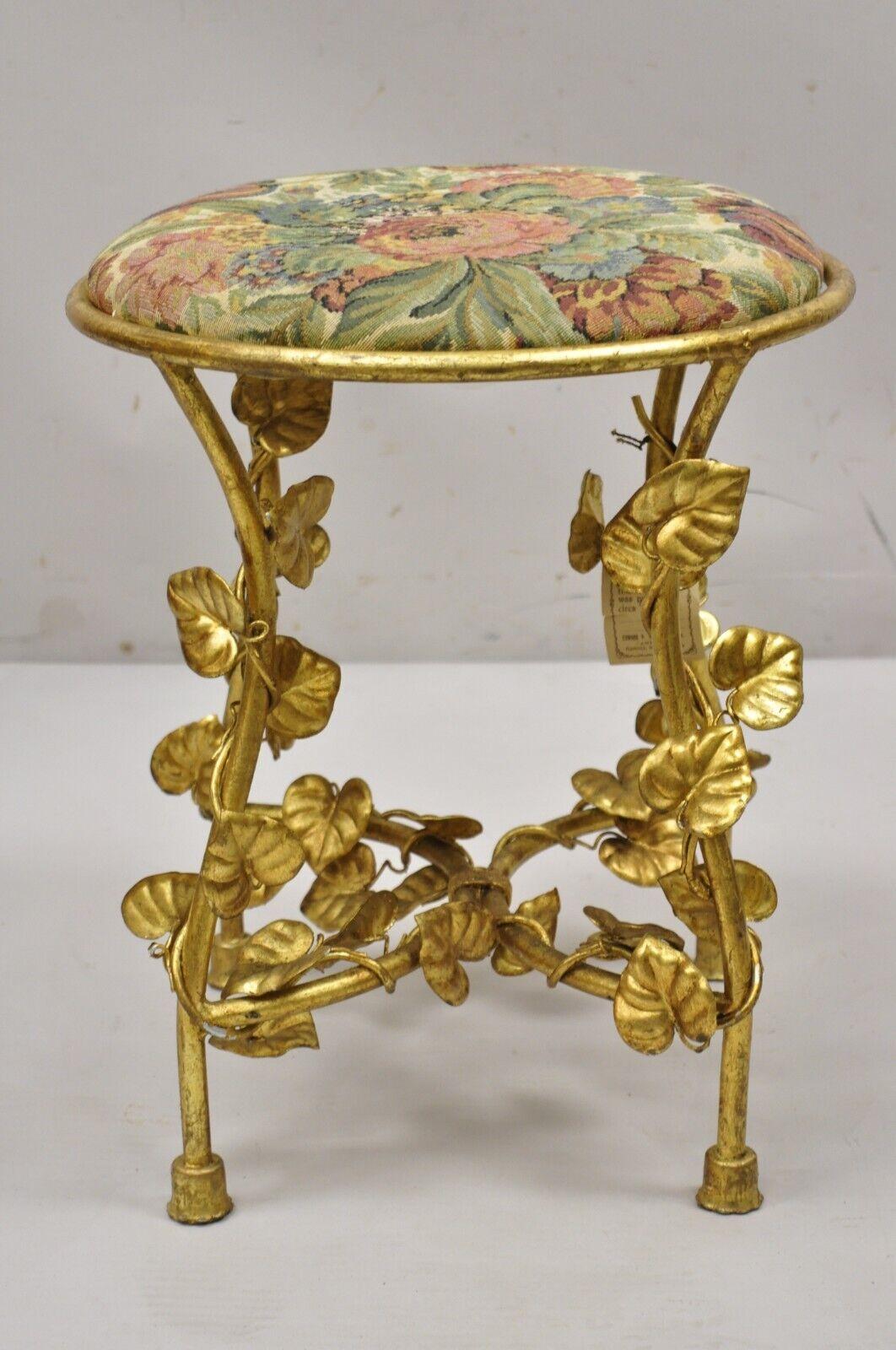 Vintage Italian Hollywood Regency Gold Gilt Leaf Accent Iron Vanity Bench Stool Seat. Item features a gold gilt leaf finish, iron frame, round floral upholstered seat, leaf accent throughout, quality Italian craftsmanship, great style and form,