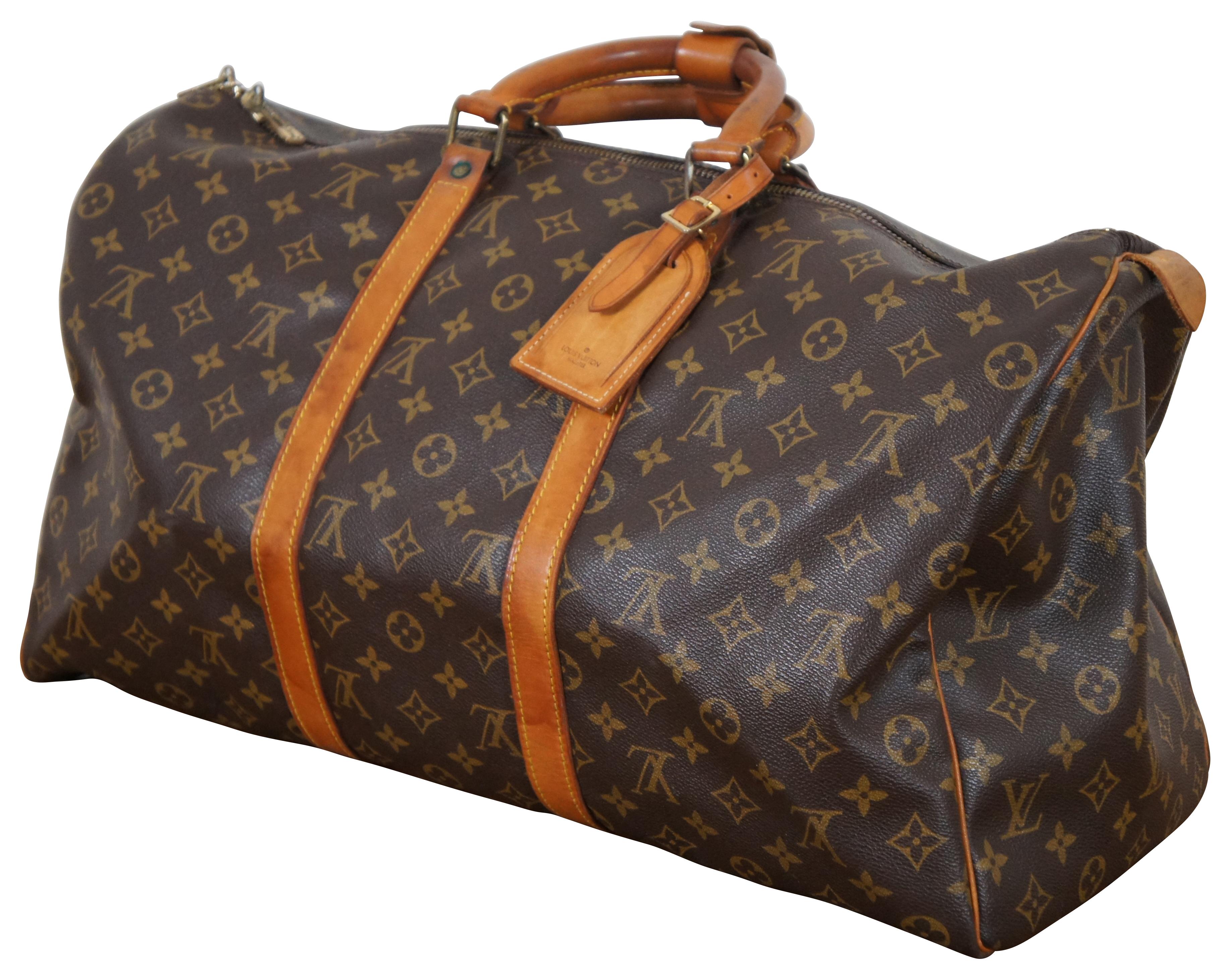 1980s Vintage Louis Vuitton Keepall Bandouliere 45 Boston duffle bag crafted from brown monogram canvas with leather straps and gold tone brass hardware. Includes luggage lock and two keys. Leather tabs marked FC892 Malletier.  Manufactured in