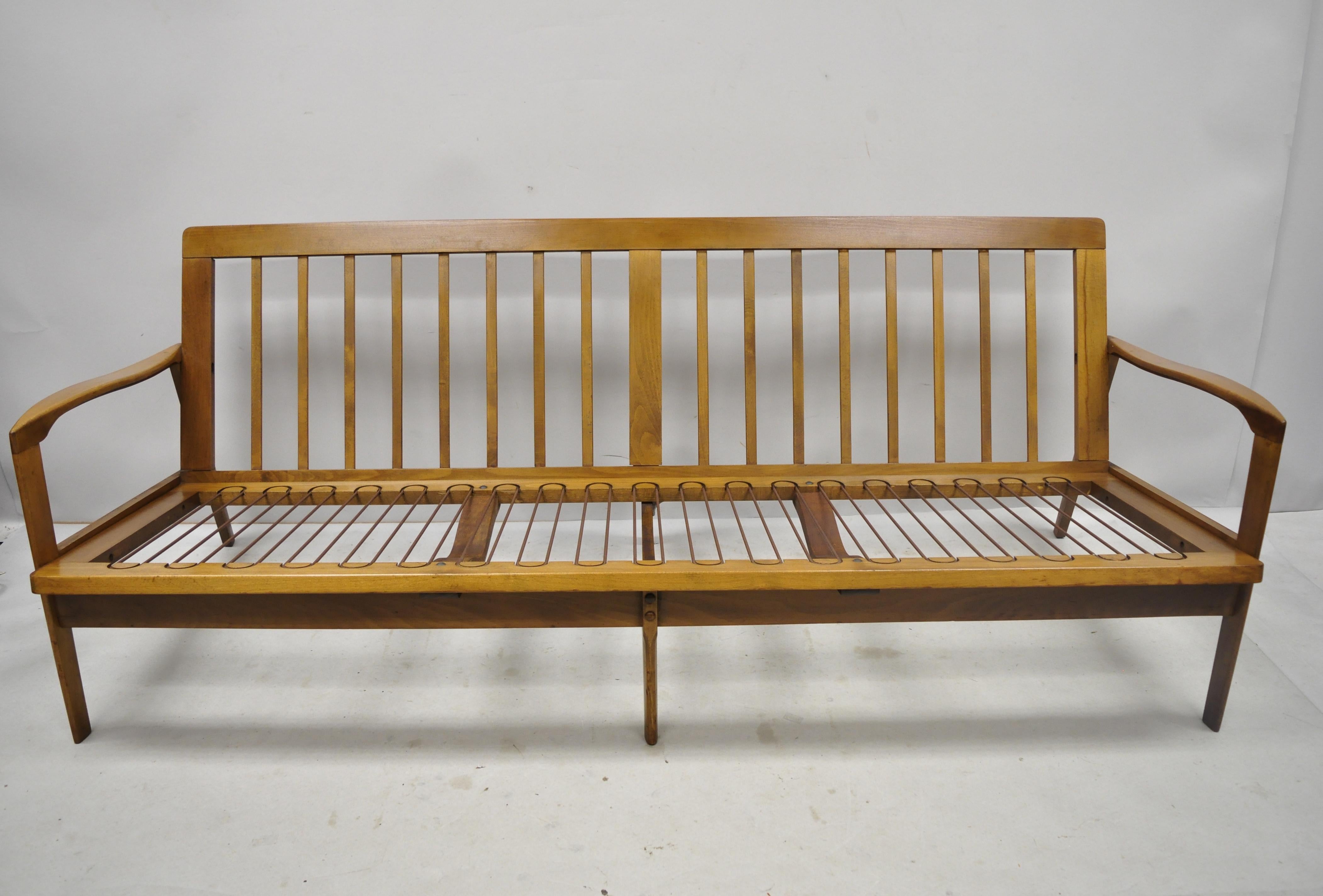 Vintage midcentury Danish modern sculpted walnut 3-seat spindle back sofa by Norco. Item includes loose cushions, solid wood frame, beautiful wood grain, original label, tapered legs,
circa mid-20th century. Measurements: 29