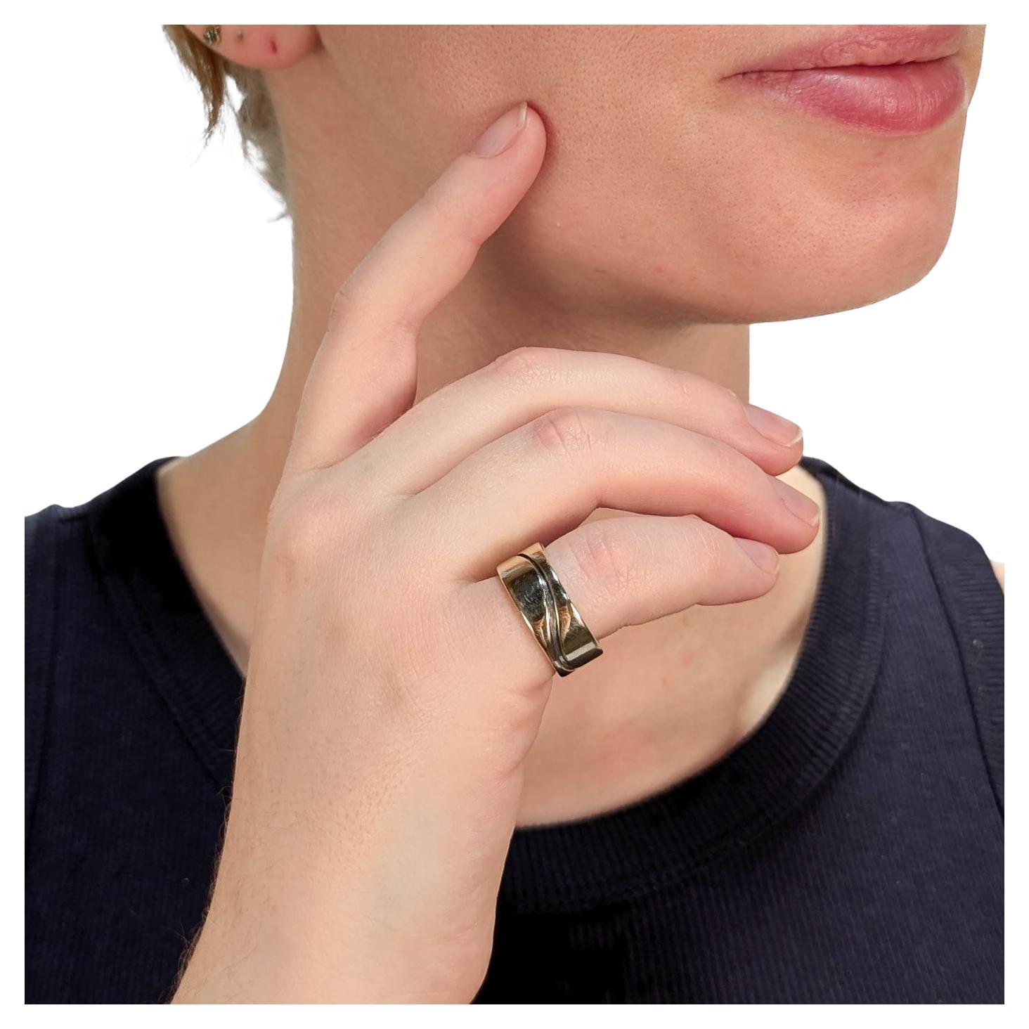 A fine signed Mid-Century Modern cigar band ring.

In mixed metals.

With a sterling silver base and thick band of 14k yellow gold on top. 

By Paul Lobel. Lobel was a Romanian-born and New York based jeweler, designer, illustrator who was an