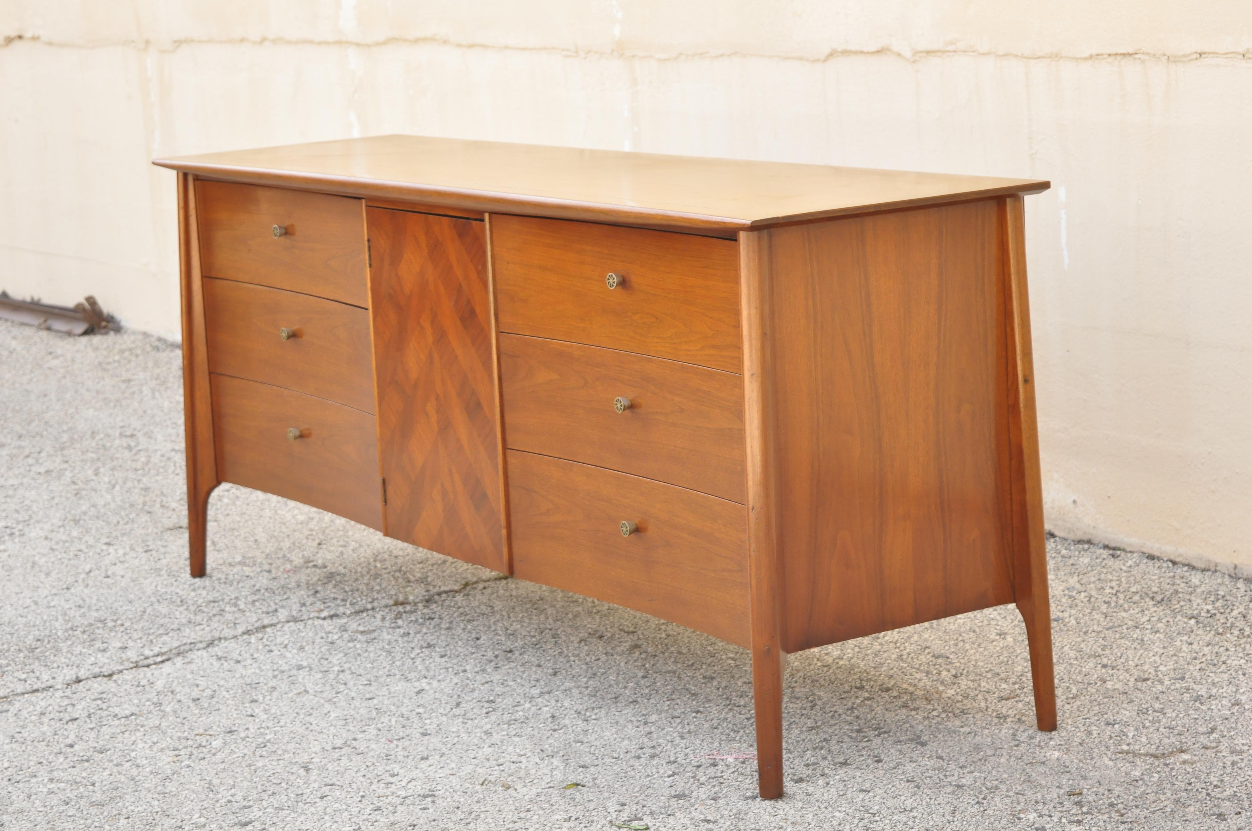 Vintage mid century sculpted walnut credenza cabinet dresser with marquetry inlay door. Item features enameled drawer pulls, curved drawer fronts, marquetry inlay door front, beautiful wood grain, 8 dovetailed drawers, tapered legs, clean modernist