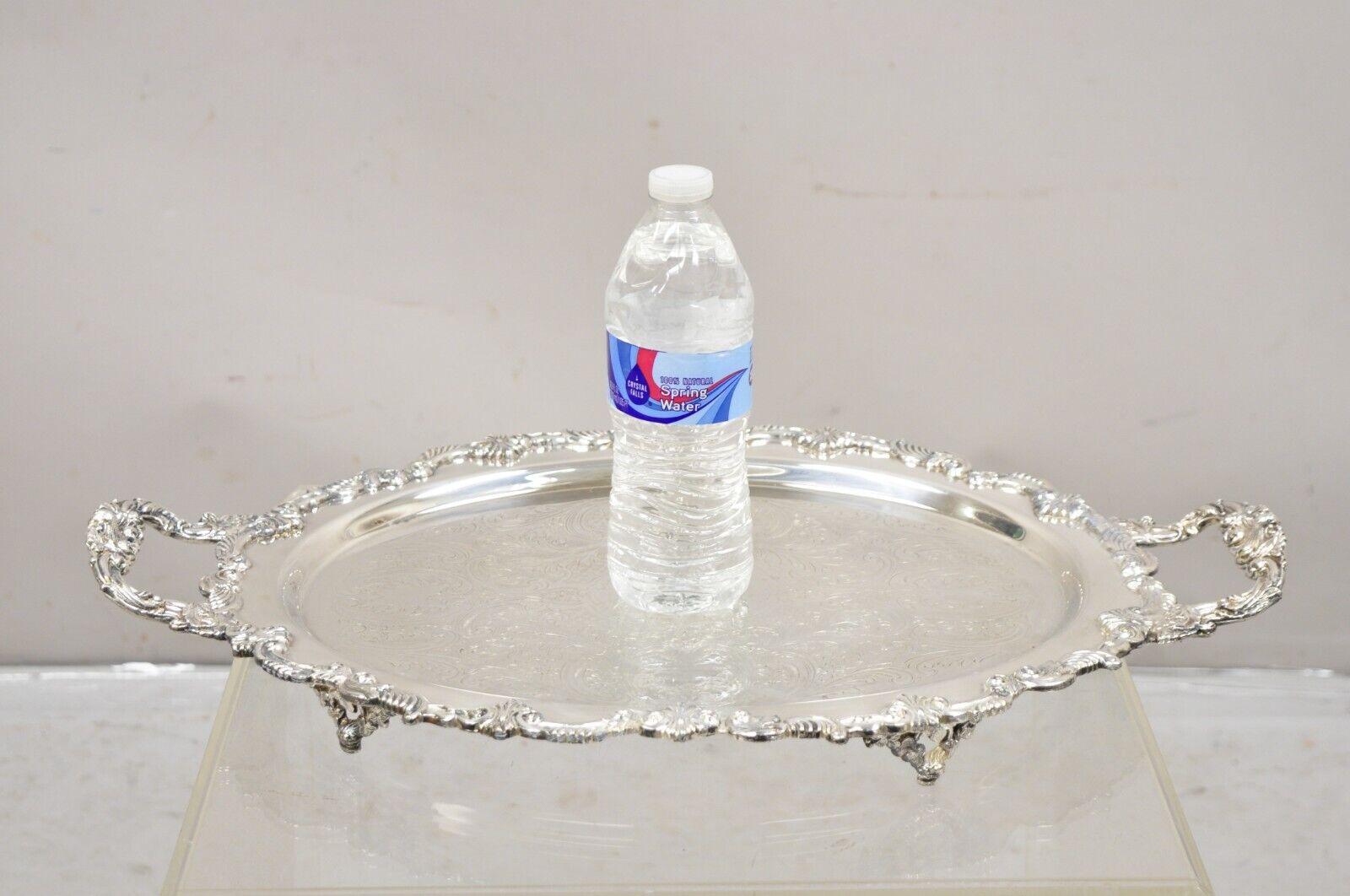Vintage Sheffield English Victorian Style Silver Plated Oval Serving Platter Tray. Item featured is raised on ornate feet, fancy twin handles, original hallmark. Circa Mid 20th Century. Measurements: 3