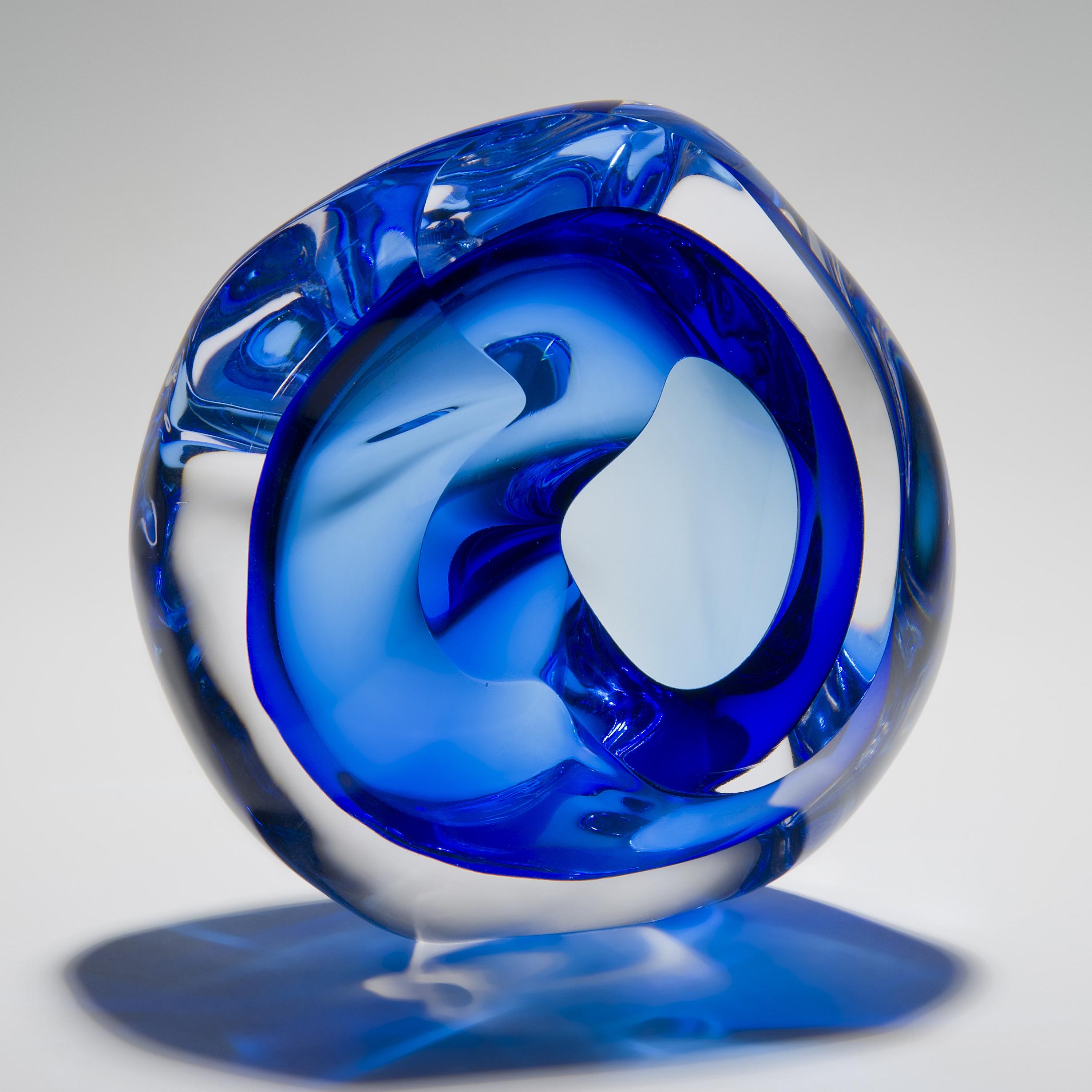 Vug in Blue is a unique hand blown sculpture by the British artist Samantha Donaldson. Created by layers of glass in blue and clear glass, these layers merge and create movement throughout the piece. An additional optical illusion is also created as