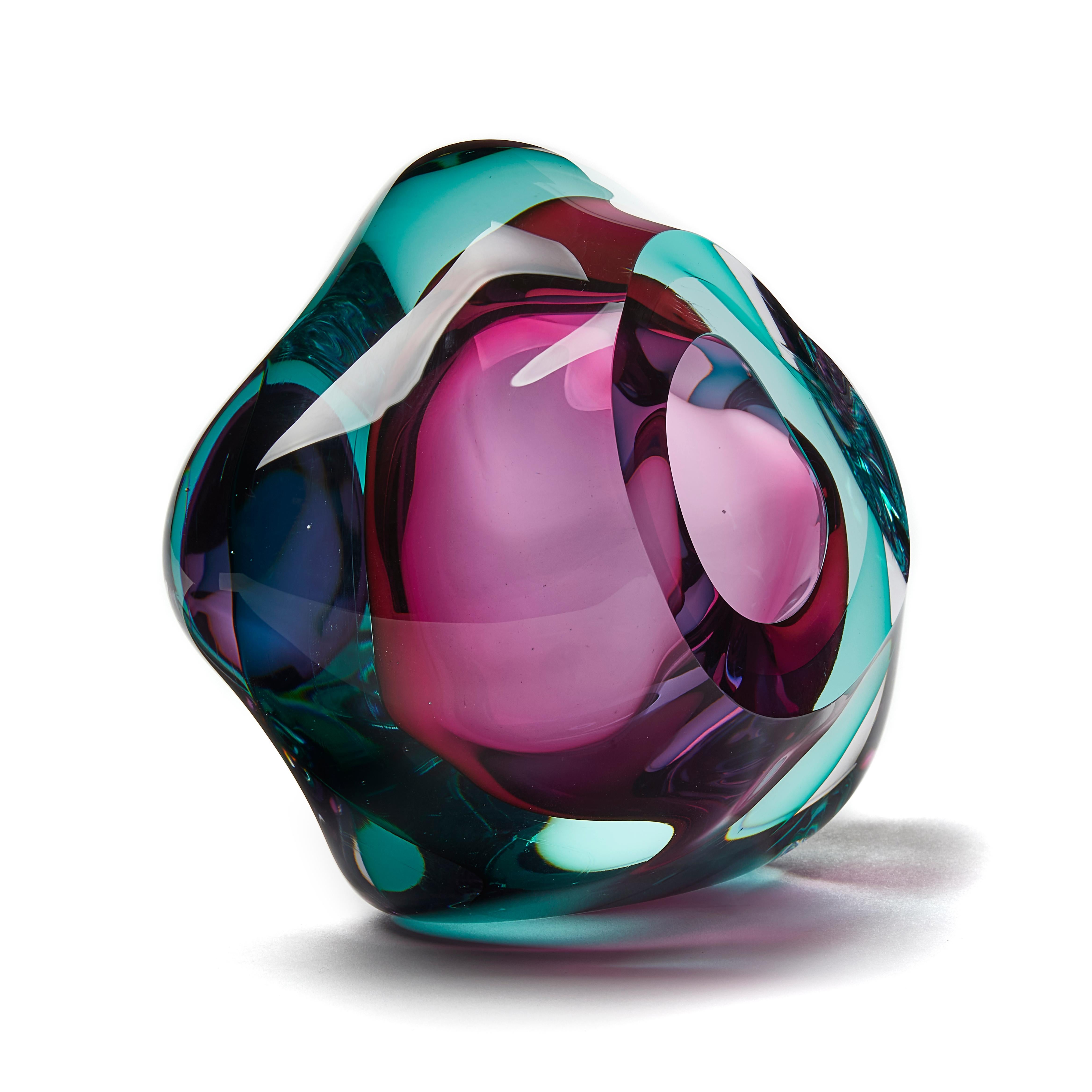 Vug in Emerald and Fuchsia is a unique hand blown sculpture by the British artist Samantha Donaldson. Created by layers of colored glass in soft emerald green and vibrant pink, the transparent colors merge and create further hues throughout the