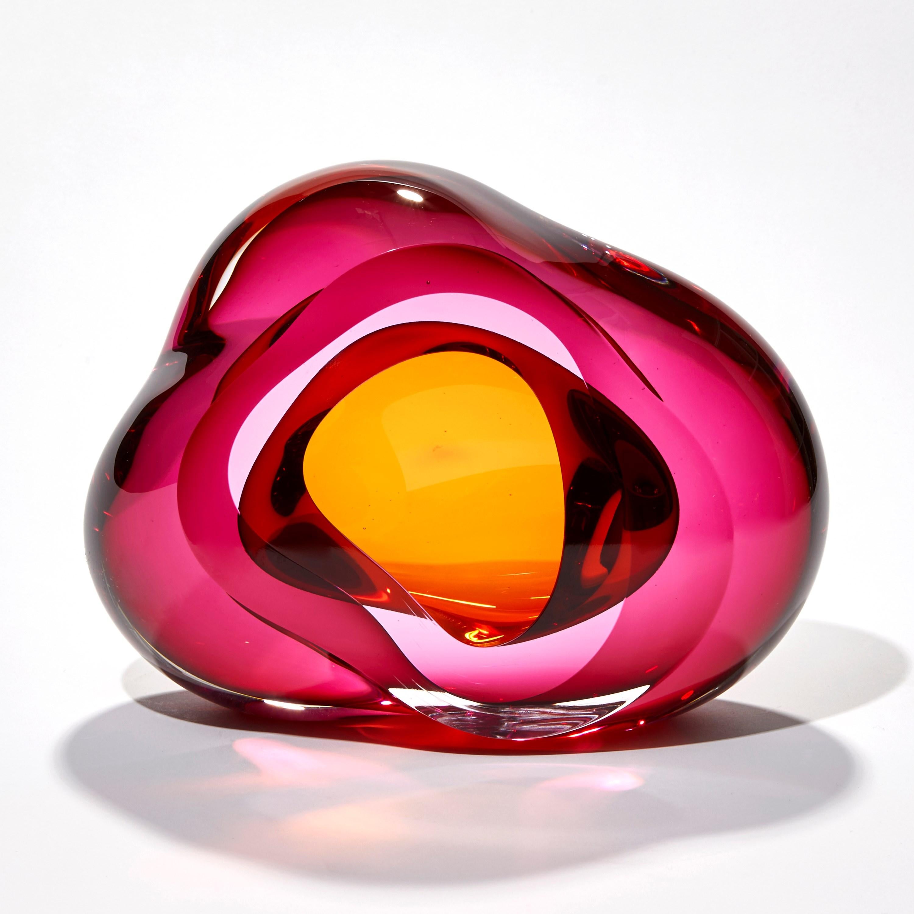 'Vug in Fuchsia & Gold II' is a unique handblown sculpture by the British artist, Samantha Donaldson.

Created by layers of coloured glass in fuchsia pink and amber/gold, the transparent colours merge and create further hues throughout the piece.