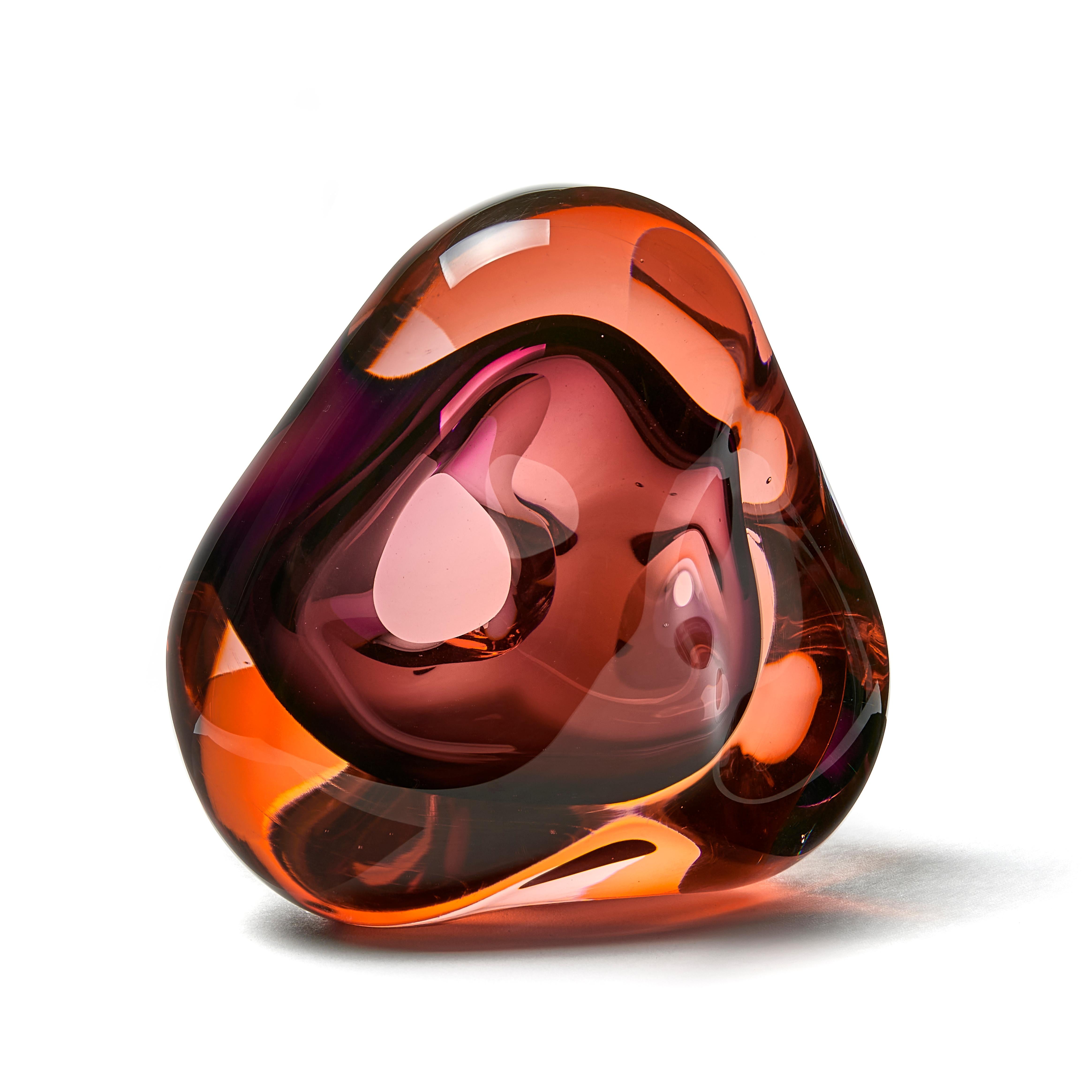 Vug in soft orange and purple is a unique hand blown sculpture by the British artist Samantha Donaldson. Created by layers of coloured glass in orangey/peach and purple, the transparent colours merge and create further hues throughout the piece. An