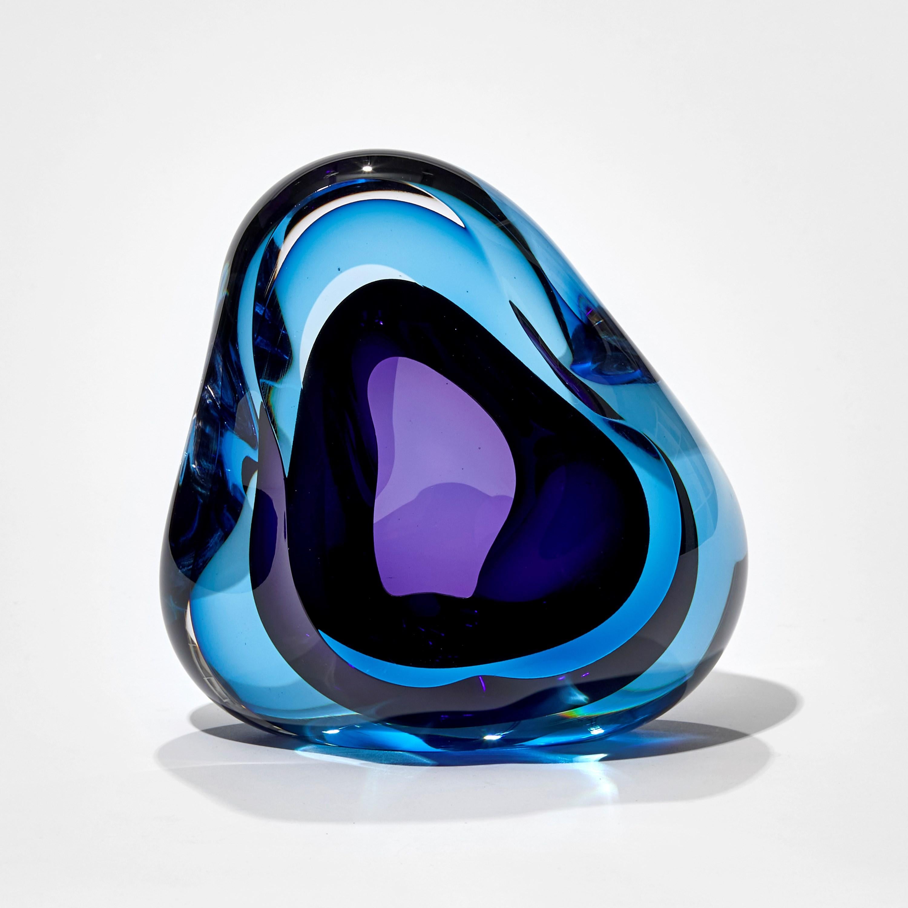 Vug in Turquoise and Purple is a unique hand-blown sculpture by the British artist Samantha Donaldson. Created by layers of colored glass in deep blue and rich purple, the transparent colors merge and create further hues throughout the piece. An