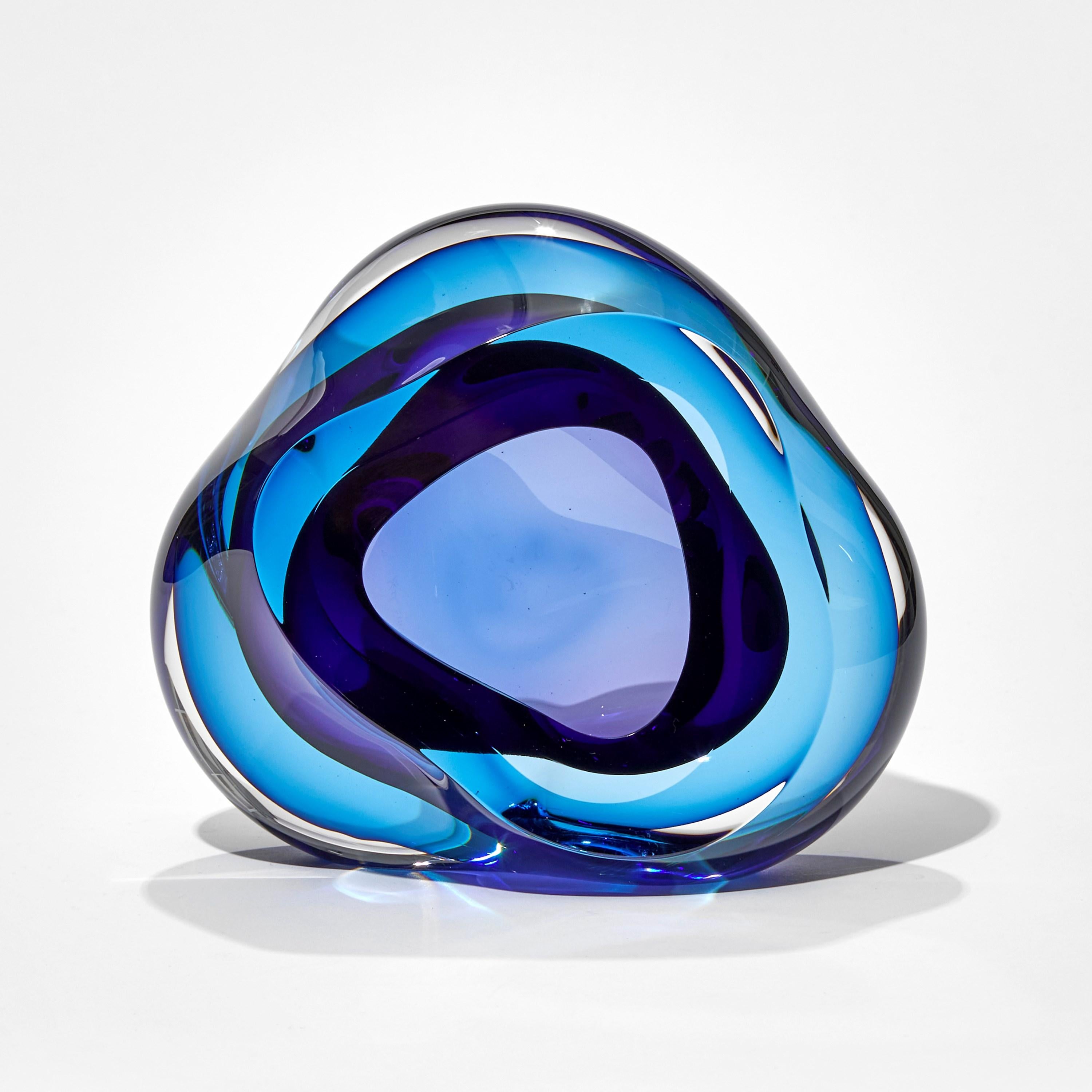 Vug in Turquoise and Purple II is a unique hand-blown sculpture by the British artist Samantha Donaldson. Created by layers of colored glass in deep blue and rich purple, the transparent colors merge and create further hues throughout the piece. An