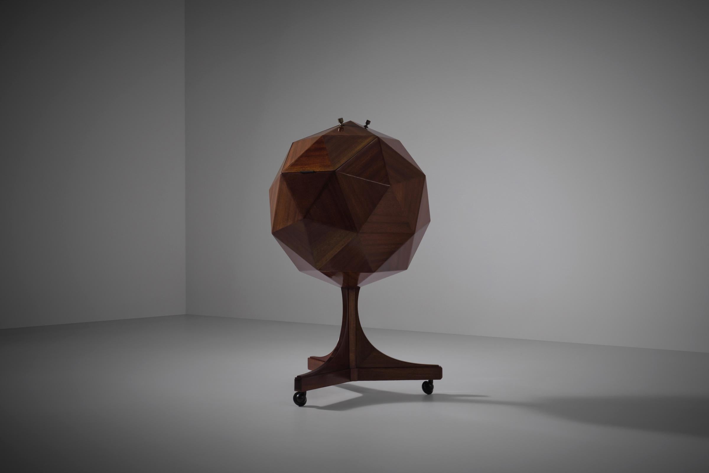 Sculptural Polyhedron shaped bar cabinet by M. Vuillermoz, 1960s. Stunning three dimensional design constructed out of solid Mahogany triangular elements merged together into a larger pentagonal shape and finished with refined brass handles and