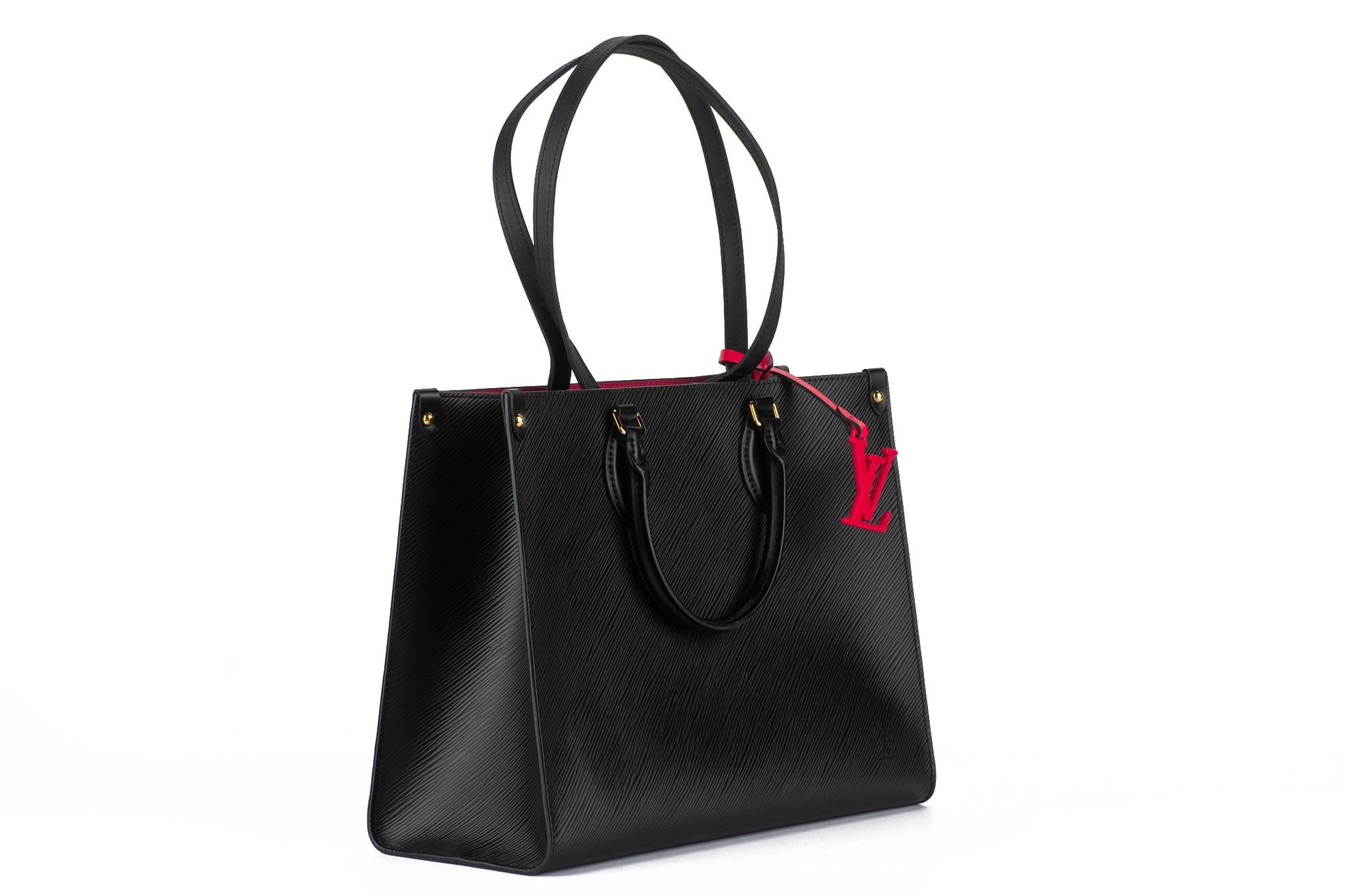 Vuitton MM on the go en cuir épi noir et intérieur et charme fuchsia. Excellent état. Les doubles poignées tombent à 5