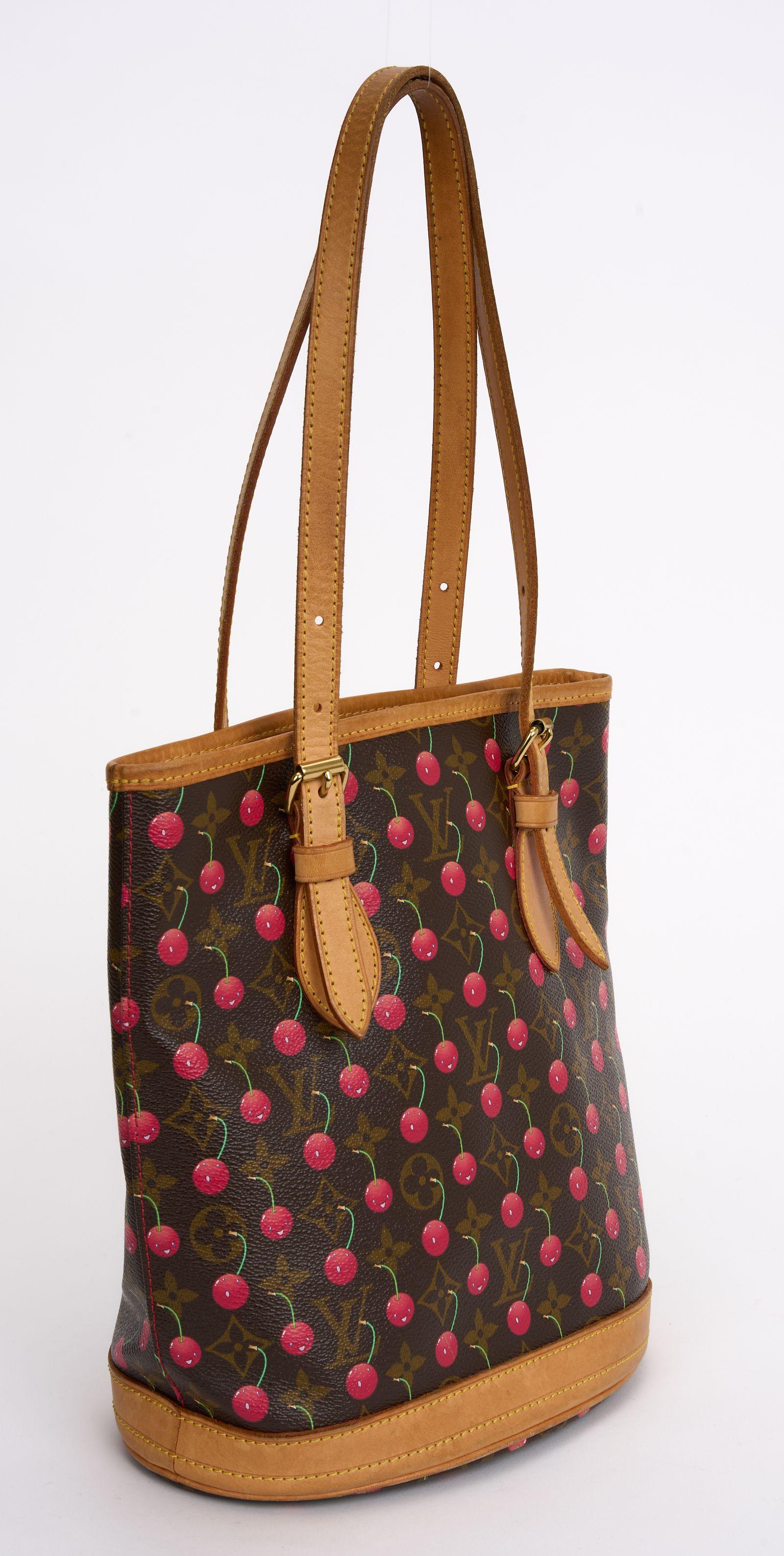 The Louis Vuitton Monogram Cerises Bucket Bag from the 2005 Collection By Murakami.  This chic bucket style shoulder bag is crafted of ripe smiley faced cherry print on Louis Vuitton monogram on toile canvas, gold hardware, leather lining, and dual