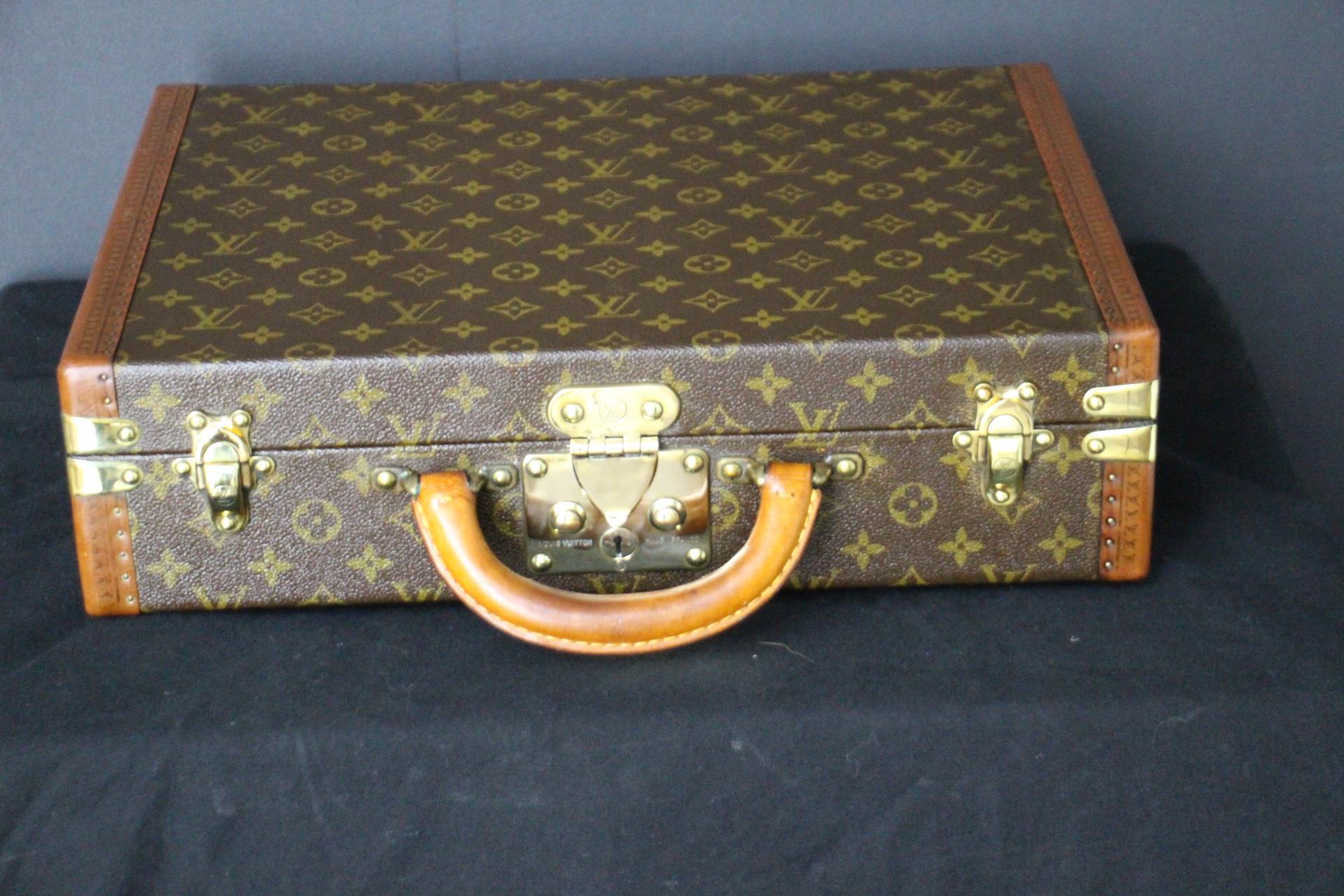 This elegant classeur briefcase features monogram canvas and a comfortable leather handle. Closed by a solid brass lock, it is accompanied by two crafted brass trunk latches. Its trims are printed with the LV logo all around.
Its interior has a