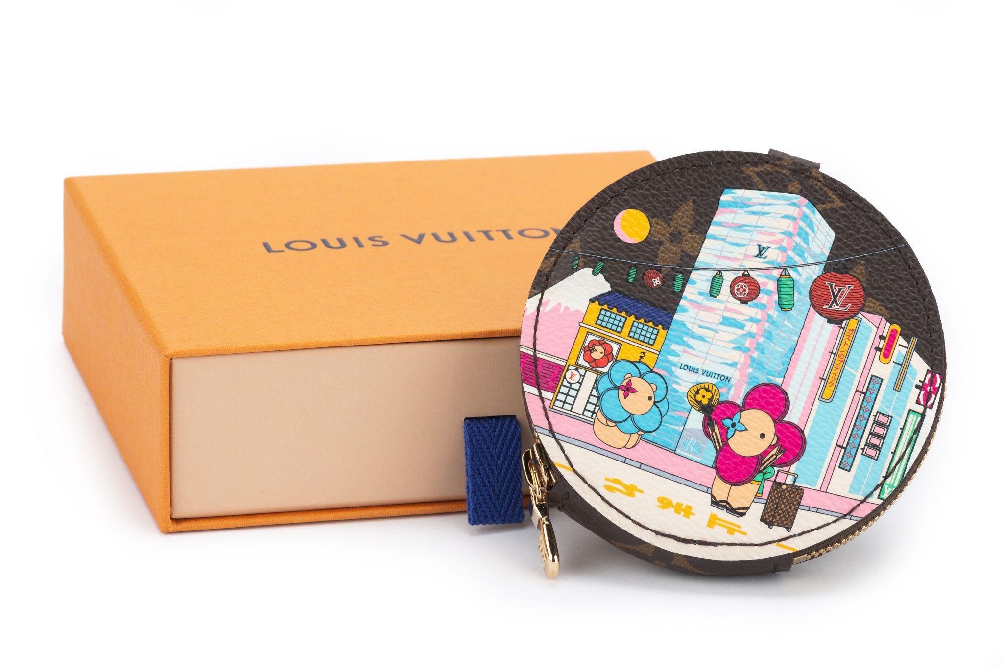 Louis Vuitton round coin purse which belongs to the Vivienne Holiday Collection 2022. In a tribute to Japan, an exclusive print shows Louis Vuitton mascot Vivienne in front of the Tokyo boutique. The item is new and comes with the box and dustcover.