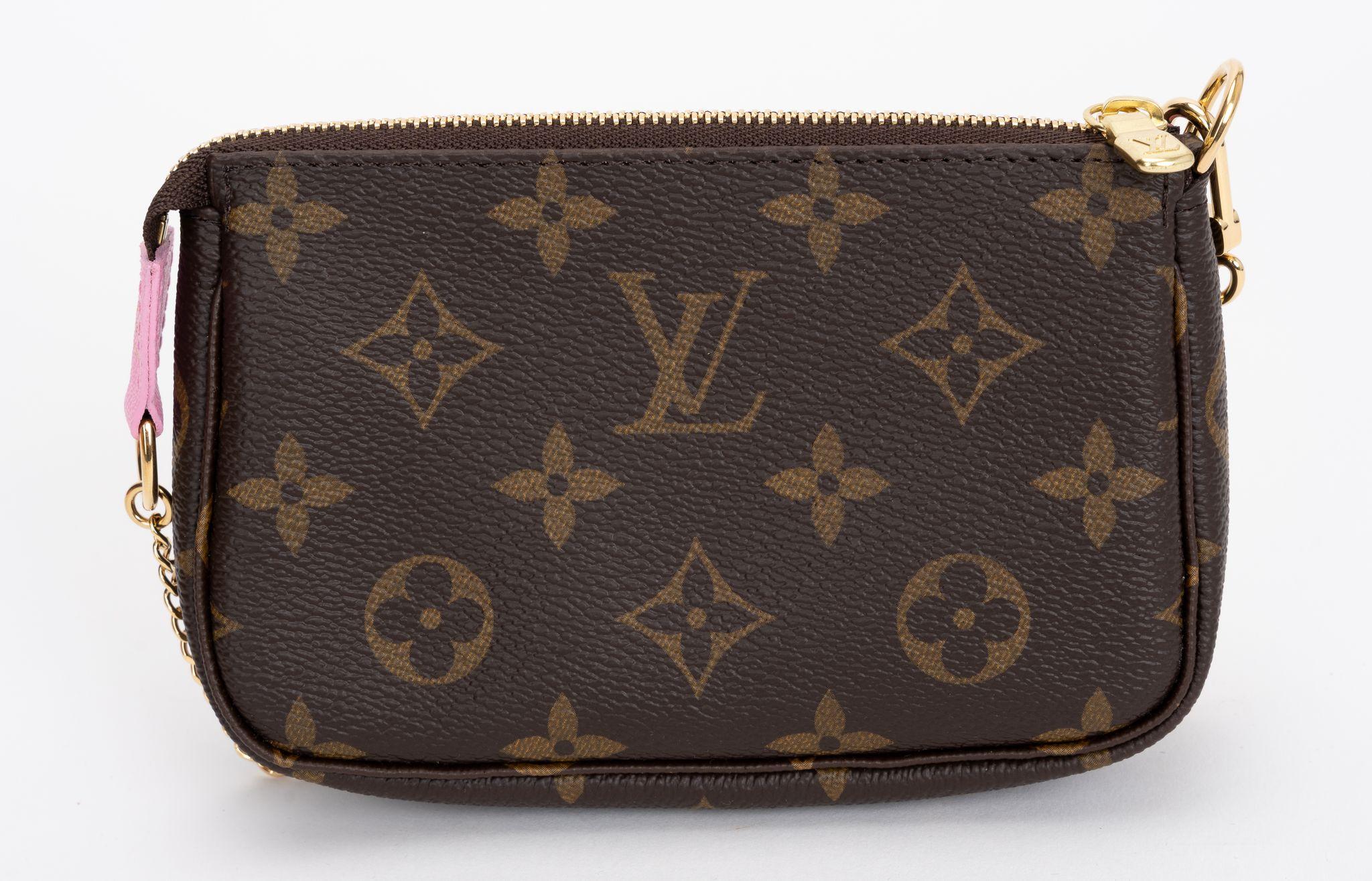 The Louis Vuitton Mini Pochette is made from monogram canvas and cowhide trim, with zipper closure. It is part of the limited edition 2023 Christmas collection. The Pochettes are decorated with an exclusive print of House mascot Vivienne and her