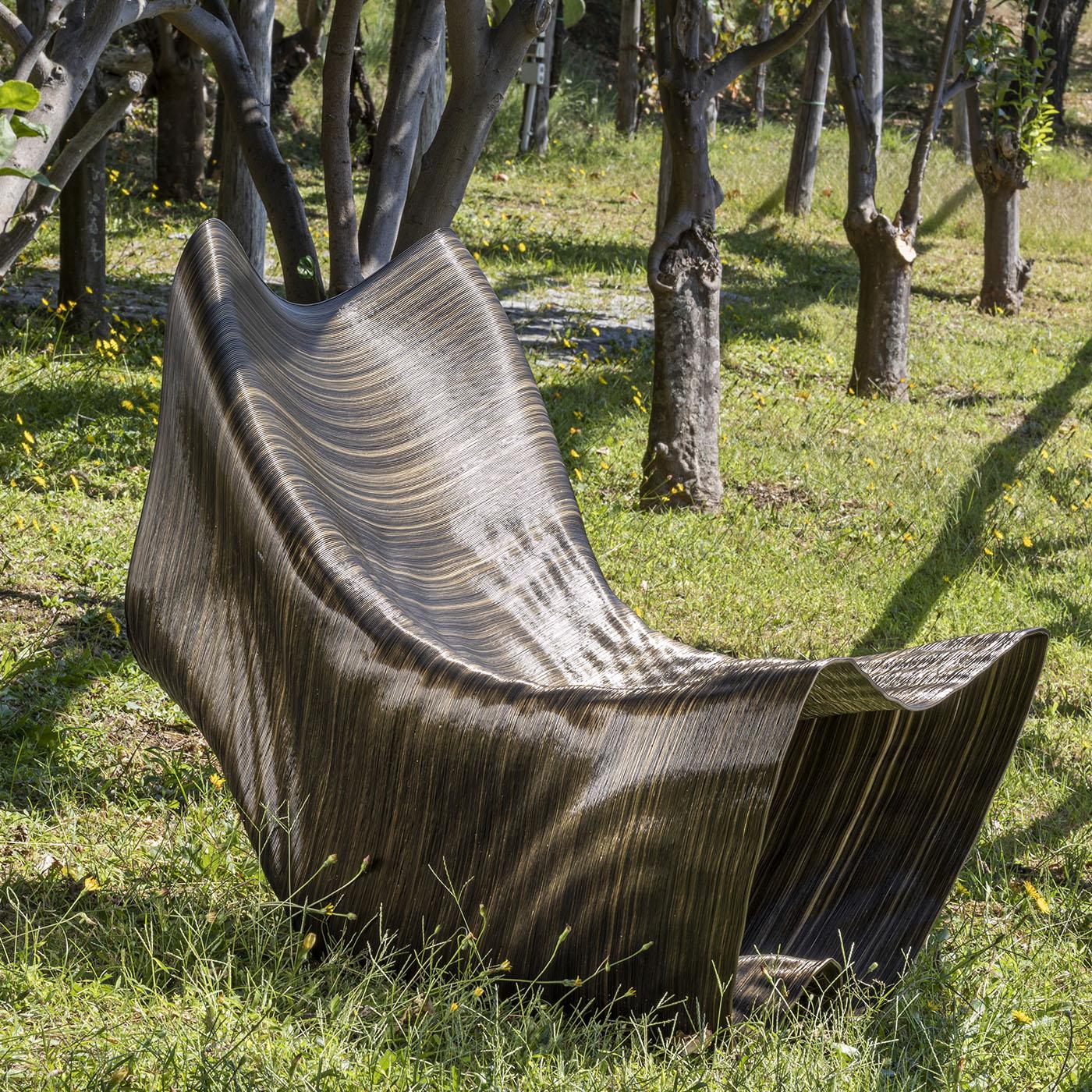 Vulcano, ein Entwurf von Medaarch aus dem Jahr 2020, stellt sich vor. Diese Chaiselongue für Außenbereiche wie Gärten oder Swimmingpools verleiht ihrer Umgebung eine starke und doch sanfte Präsenz. Seine gewellte Oberfläche ahmt das vom Wind