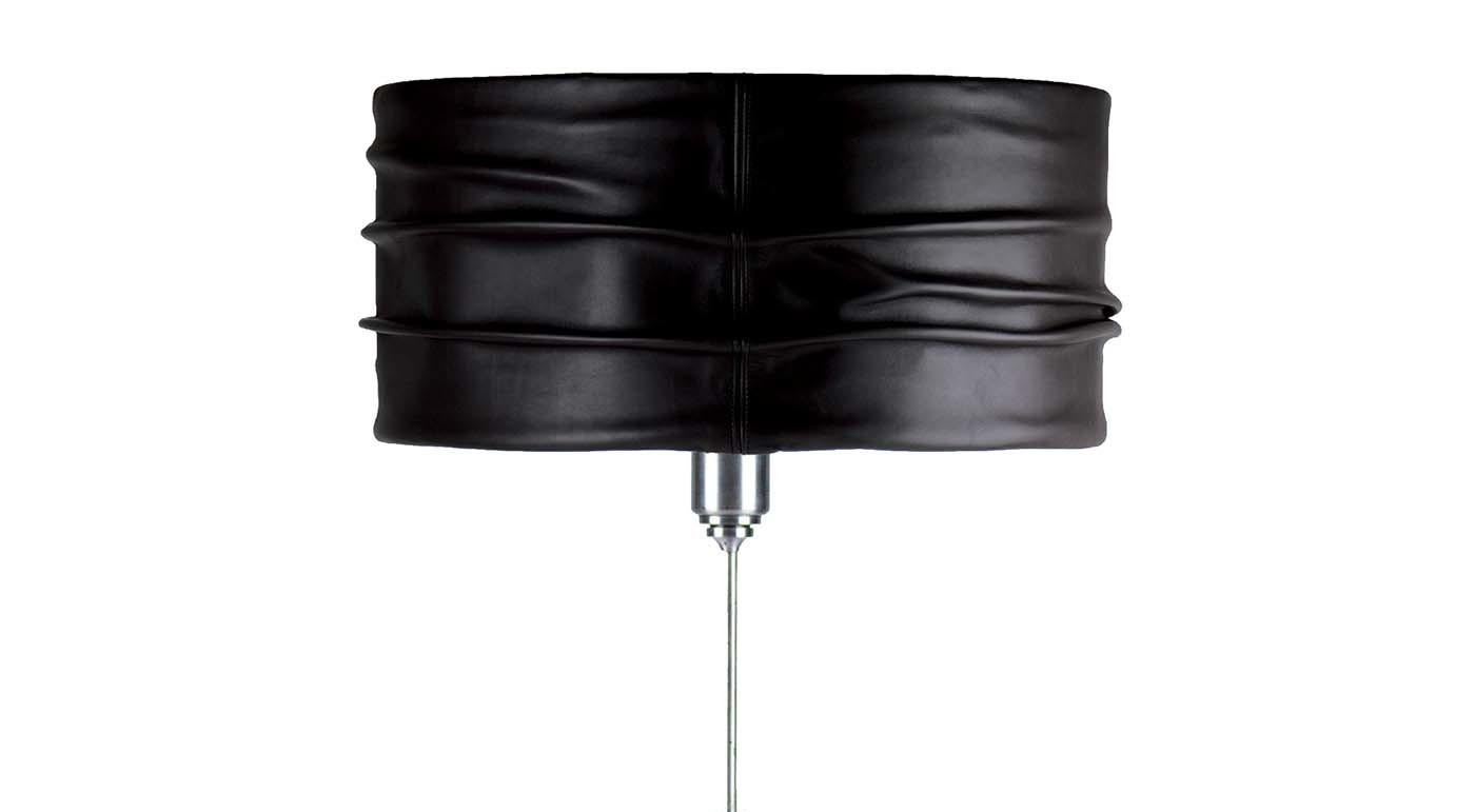 Designed with modern minimalism in mind, this table lamp brings style to any room. The ruched drum shade in deep black leather lends glamorous allure and mirrors the color of the polished matrix marble base, the two contrasting textures creating an