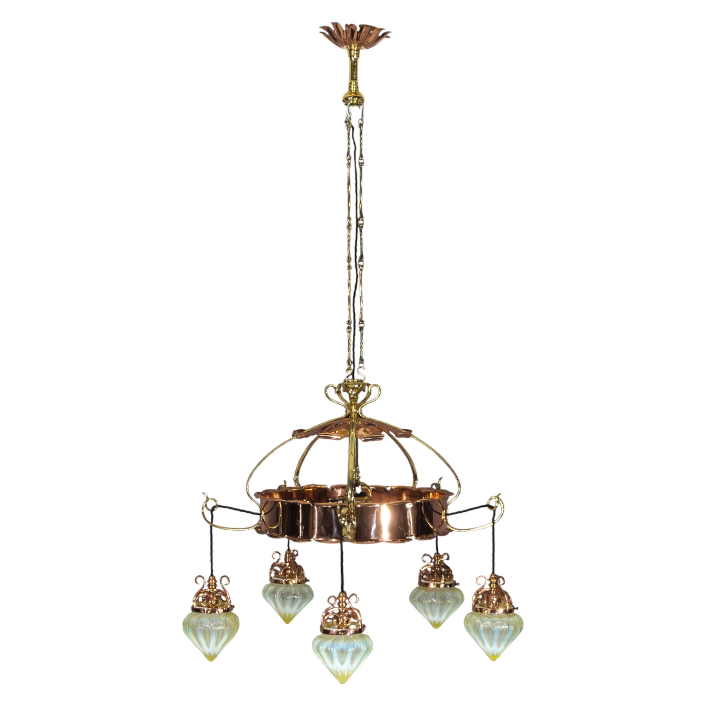 W. A. S. Benson

Un raro lampadario a cinque bracci in rame e ottone di Decorative Crafts con la piastra originale in alto e un supporto tornito in basso, che si collega a cinque bracci a frusta con una piastra decorativa superiore in rame con bordi
