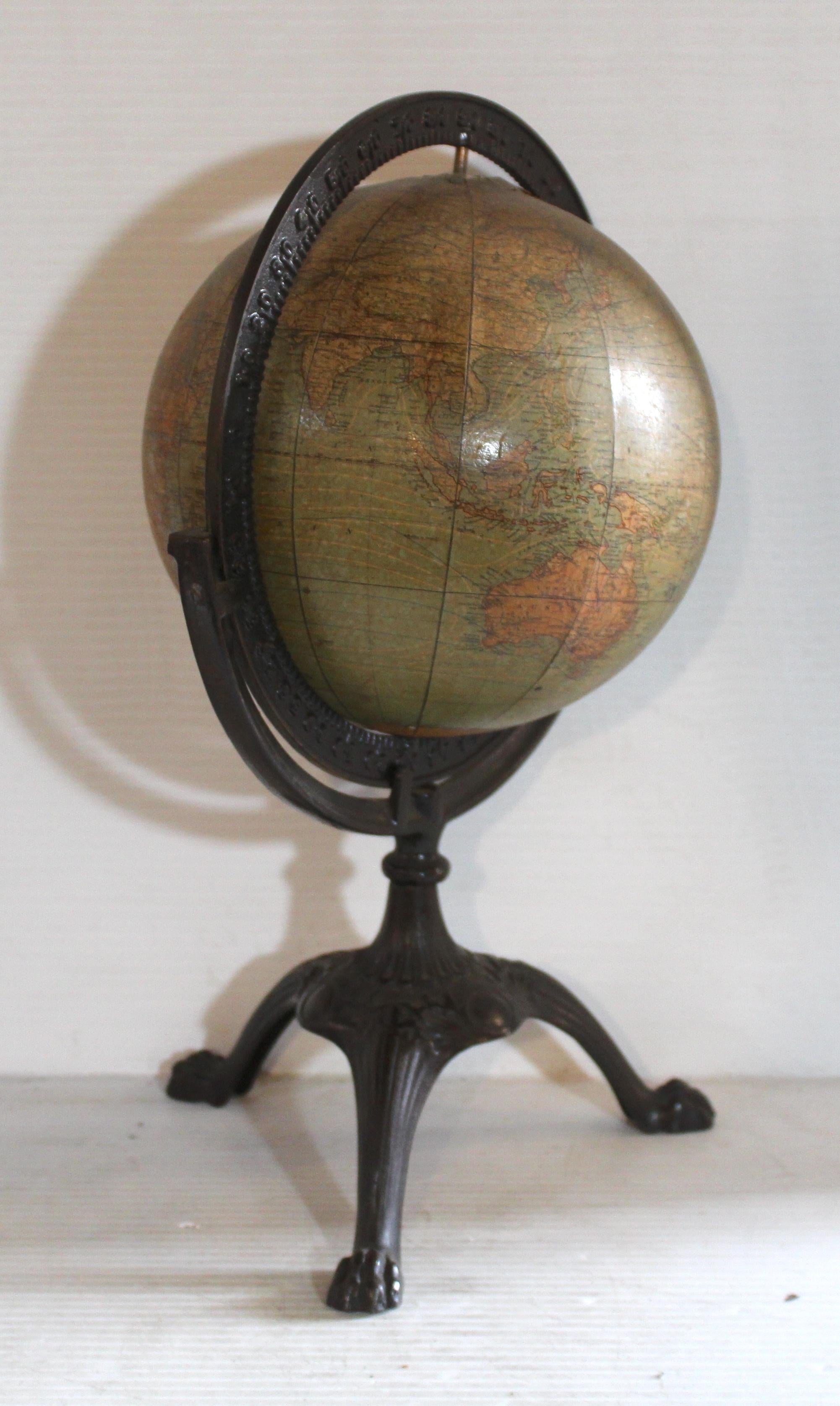 Ce globe antique a été fabriqué par W. & A.K. Johnston, entreprise écossaise fondée en 1825. L'ensemble est placé dans un socle en fonte avec des pieds griffus. Le globe peut tourner et se retourner à l'aide de l'anneau d'axe en métal.
Veuillez