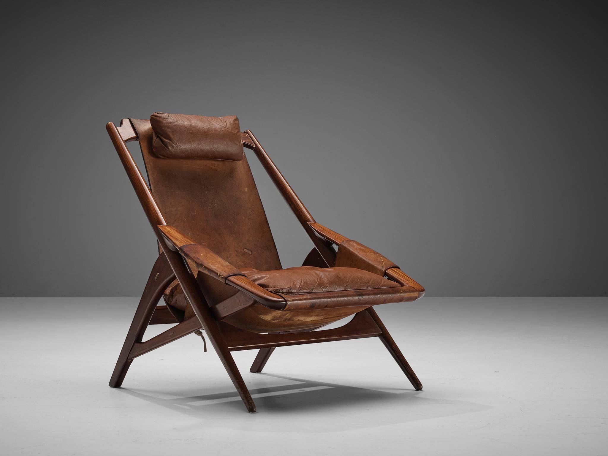 W.D. Andersag, lounge chair, wood, leather, Italy, 1960s.

This chair has a very dynamic appearance by means of the sharp lines discernible in the wooden frame. The solid construction reminds of the sturdy hunting chairs. Thick dark leather is