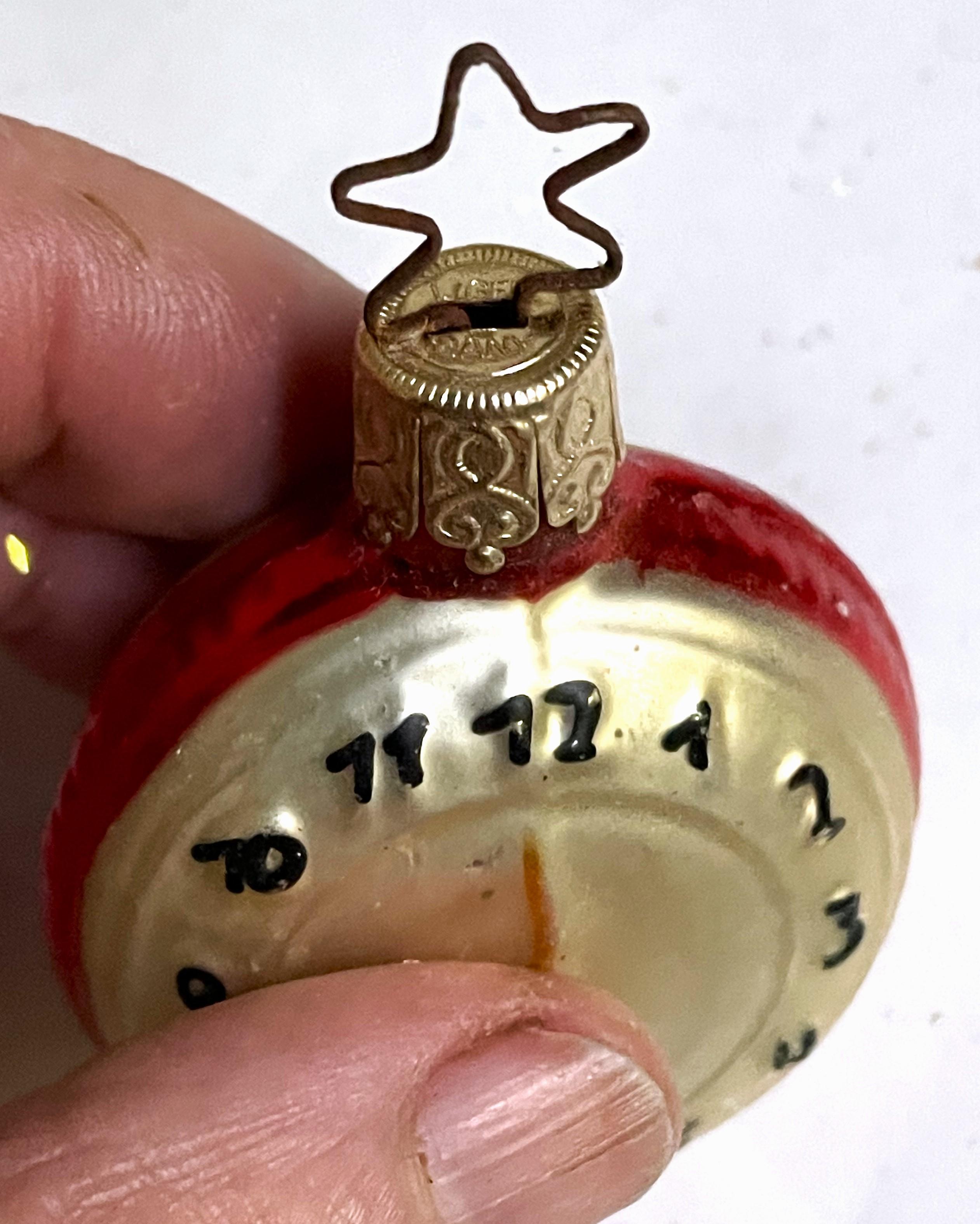 This is a fun vintage hand blown ornament of a pocket watch or clock with a time of almost quarter to 12. There is some minor scratching and signs of age but it is mostly in nice vintage condition. The cap is marked W. Germany and the very top is