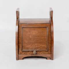 W J Neatby attri. An Arts & Crafts oak coal box with stylized carrying handles