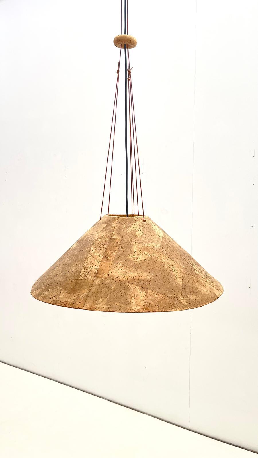 Lampada a sospensione di forma rotonda in sughero di Willhelm Zanoth e Ingo Maurer della fine degli anni '70

Con il tempo e l'uso, il paralume si deforma e non rimane perfettamente rotondo.
Il paralume è appeso a tre corde di cuoio unite da un