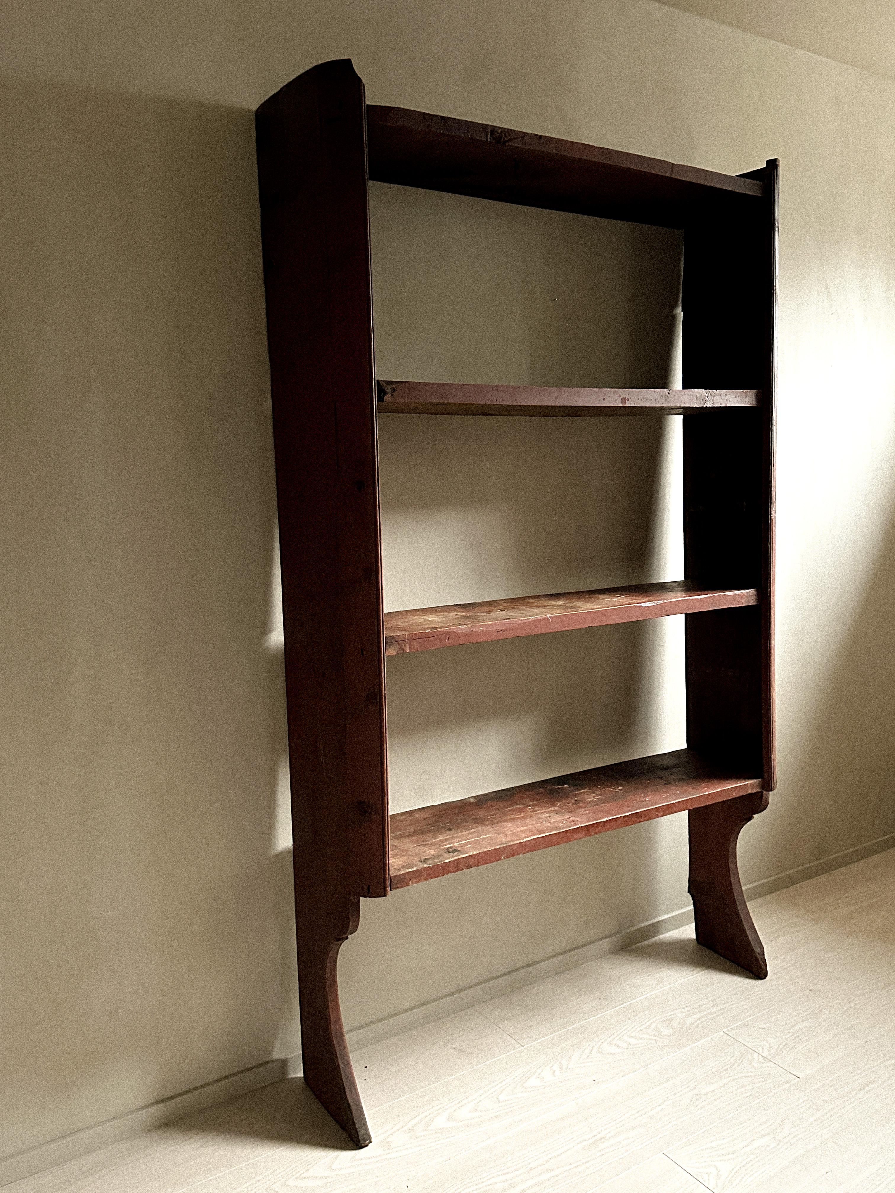 Beautiful antique book shelf in pine. Handcrafted by a Swedish cabinetmaker in the mid 1800s.

A great vintage book shelf with a lovely patina. Original deep red paint. Should be attached to a wall to ensure stability. 

A unique rustic piece that