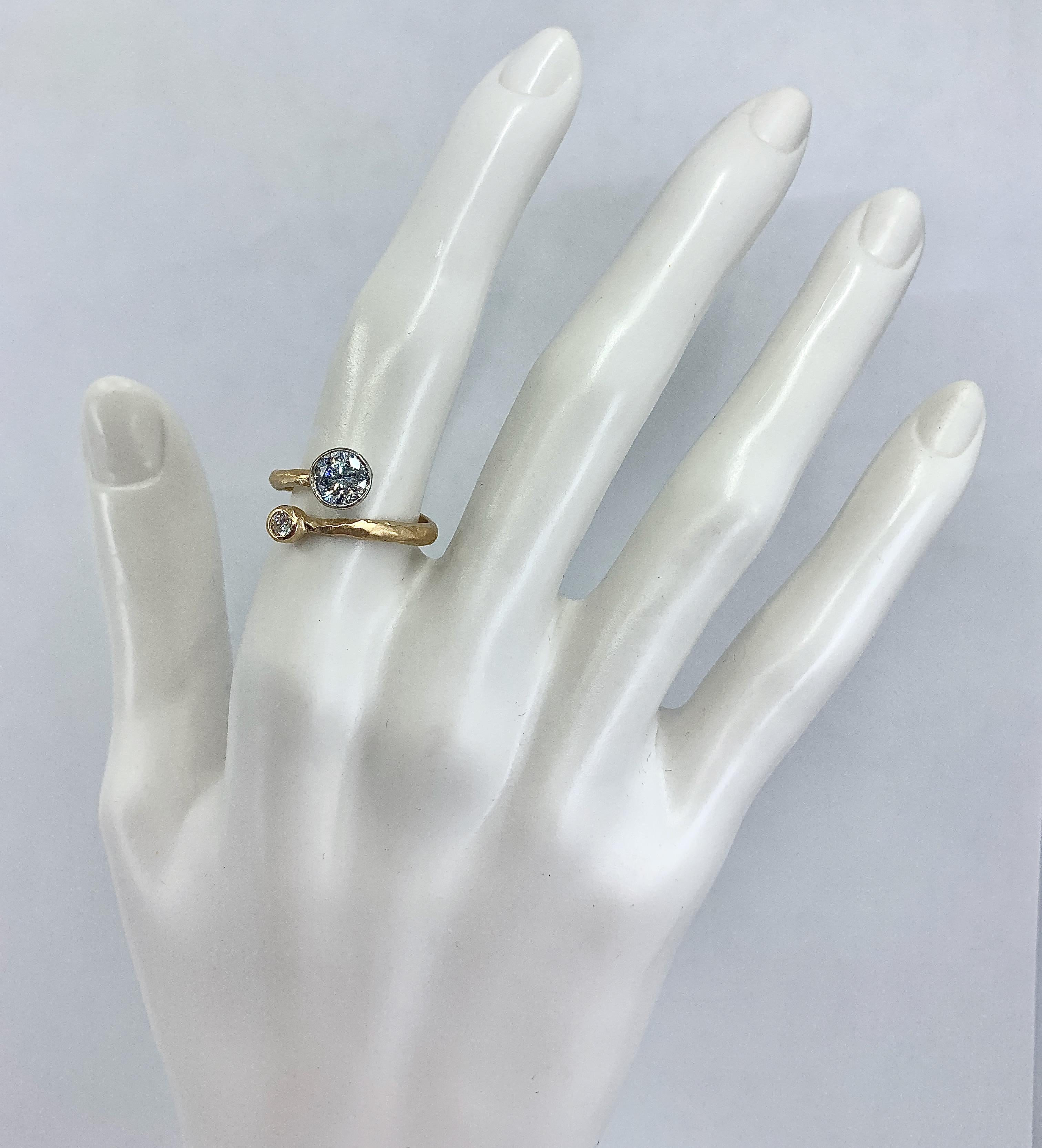 This quirky, eye-catching bypass ring by Eytan Brandes features one large and one small diamond set in a band of hammered and brushed 18 karat gold.  The large diamond is very low clarity (SI3).  However, it's so included -- you can see spots of