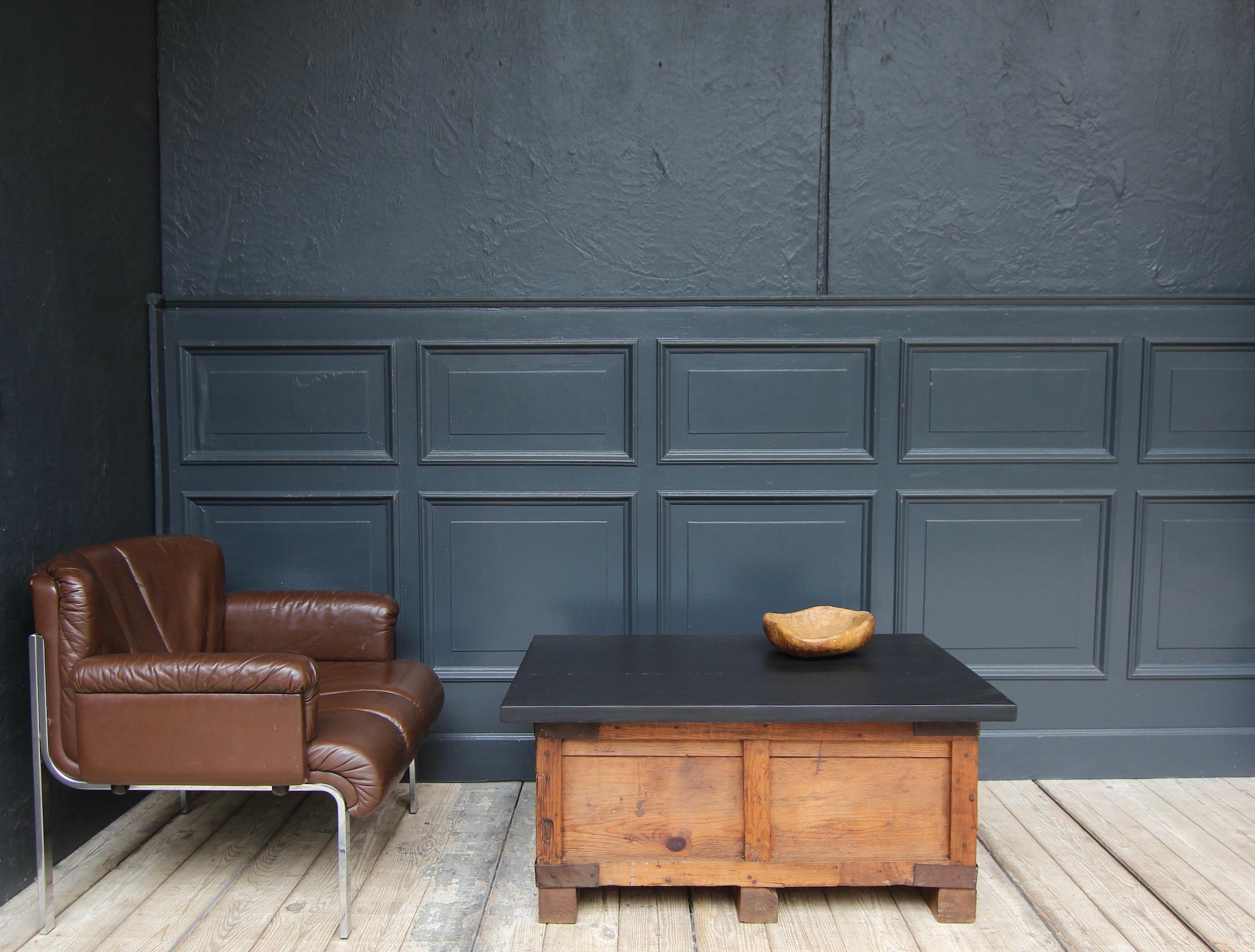A beautiful unique wabi sabi coffee table.

Consisting of an antique transport crate and a rectangular black hardwood top that protrudes all the way round. The crate is made of pine wood and fitted with metal brackets at the corners.

Markings