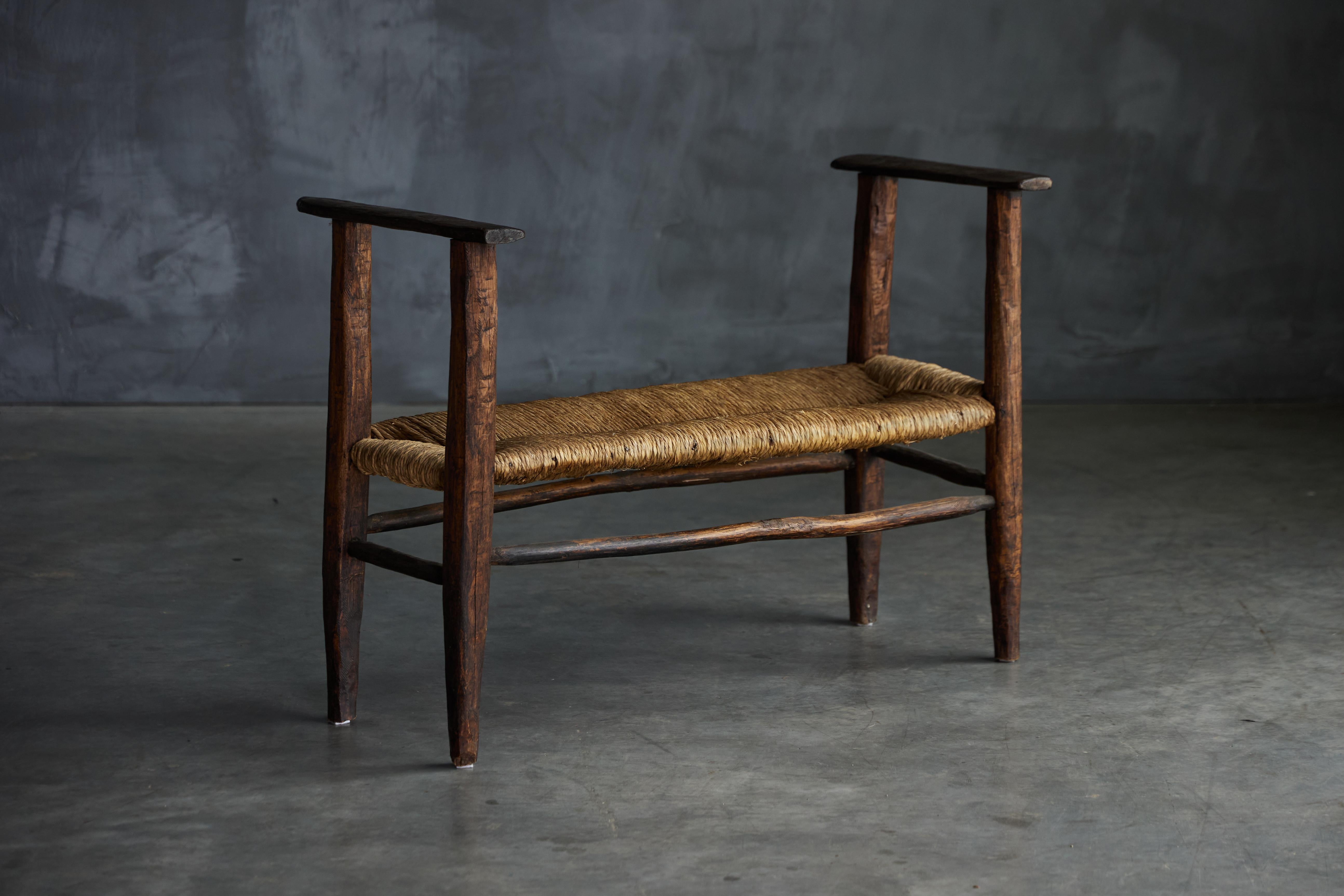 19th-century rustic wabi sabi bench, a unique piece hailing from the picturesque region of Auvergne in the heart of Rhône-Alpes, Cantal, France. Handcrafted from the finest dark solid wood, this exceptional piece embodies the region's distinct
