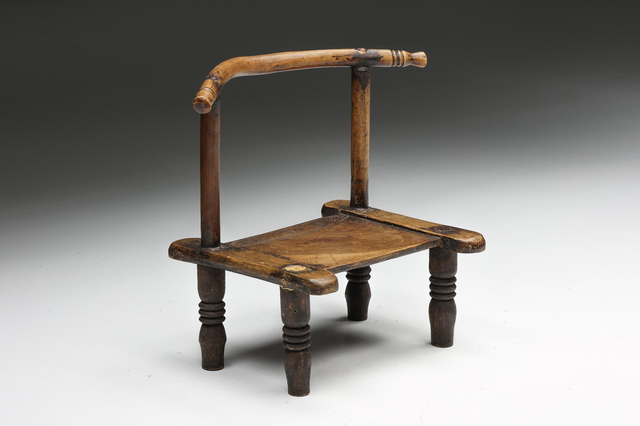 Chaise en bois rustique française, incarnant l'essence de la philosophie wabi-sabi. Réalisée avec un art méticuleux, cette pièce est une expression unique de la beauté organique, caractérisée par un remarquable travail du bois et une patine