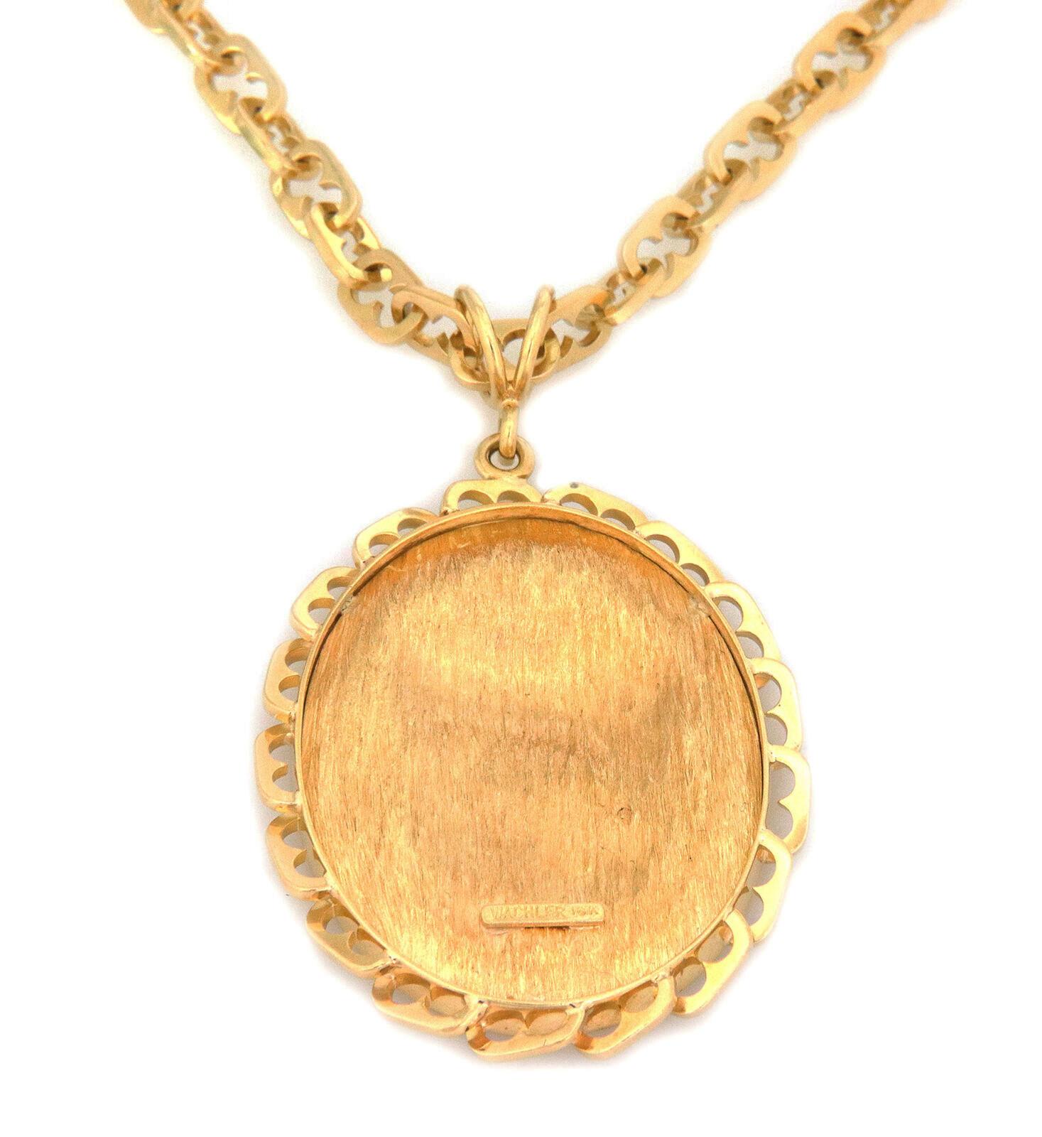 This estate signed Wachler pendant and chain is crafted from 18k yellow gold. The pendant features an indent oval frame with similar mariner design links border as the chain. The center of the oval pendant has a lovely, embossed details head of a