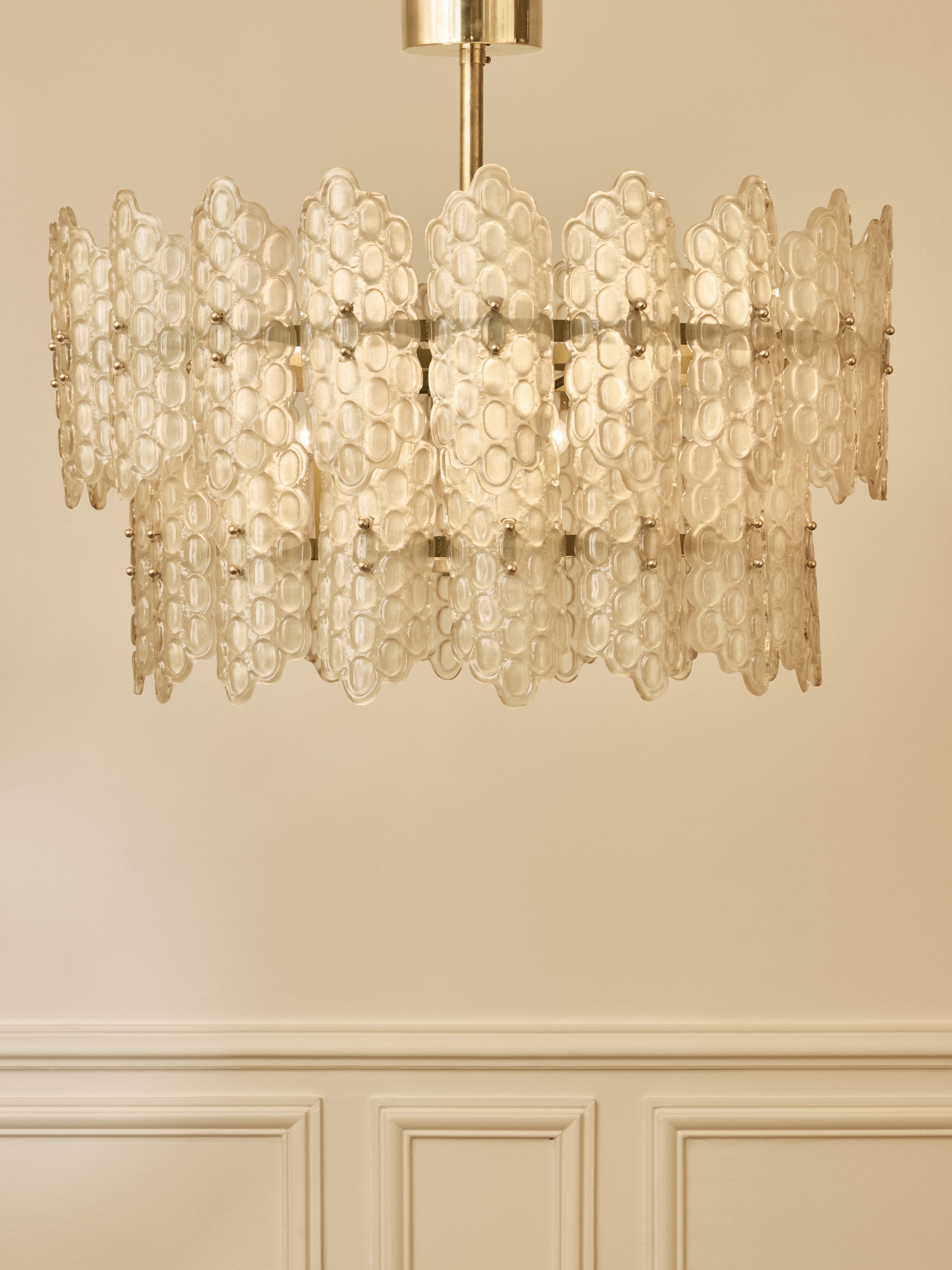 Lustre en laiton avec plaques de verre de Murano sculptées.
Création par le Studio Glustin.