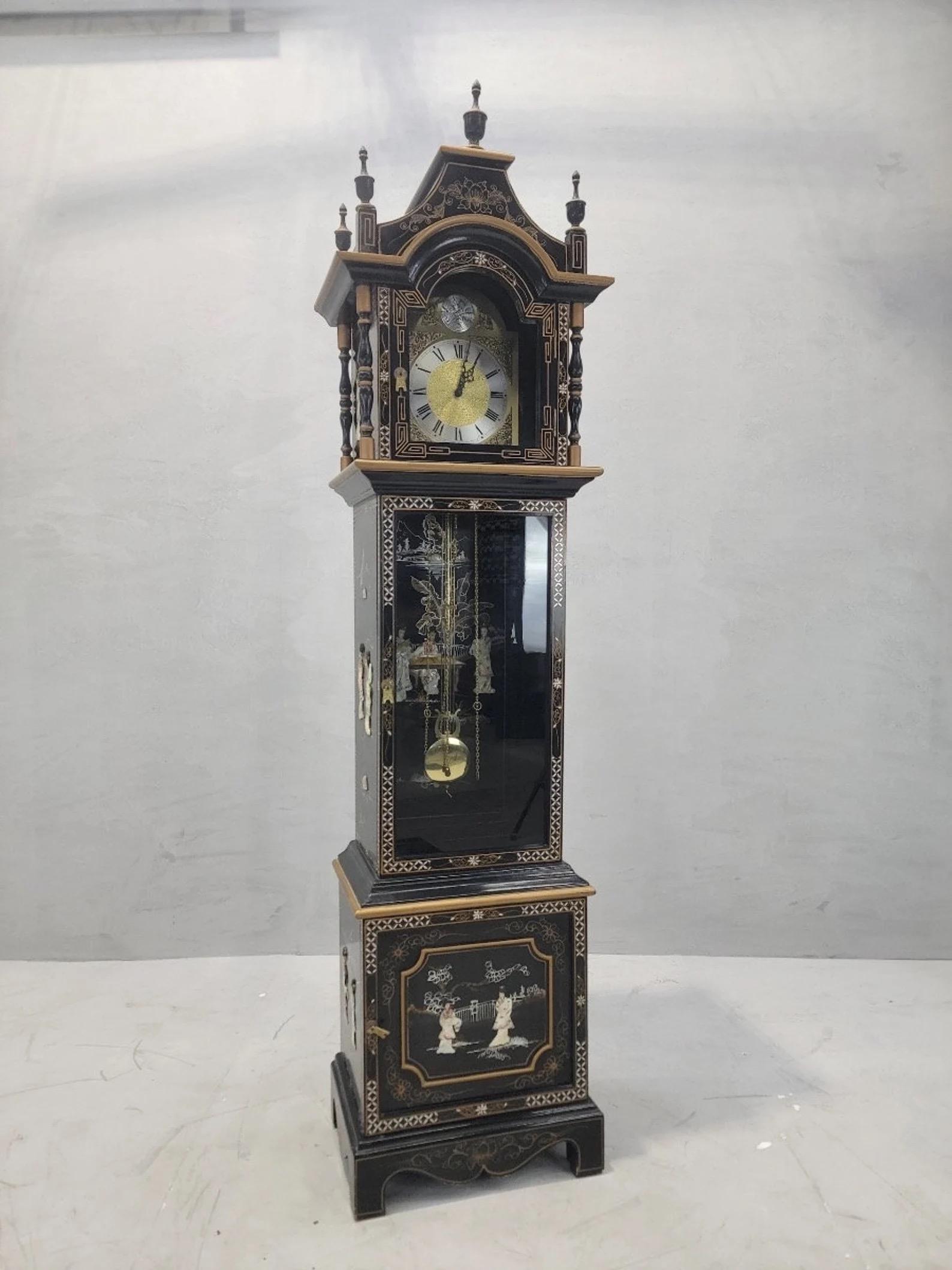 Vintage Wai Hing Clocks Co. Chinossorie Laque noire peinte à la main Nacre incrustée Mouvement allemand Tempus Fugit Horloge grand-père

Cette horloge grand-père en laque noire est ornée de nacre sur chaque panneau. De belles dames sont représentées