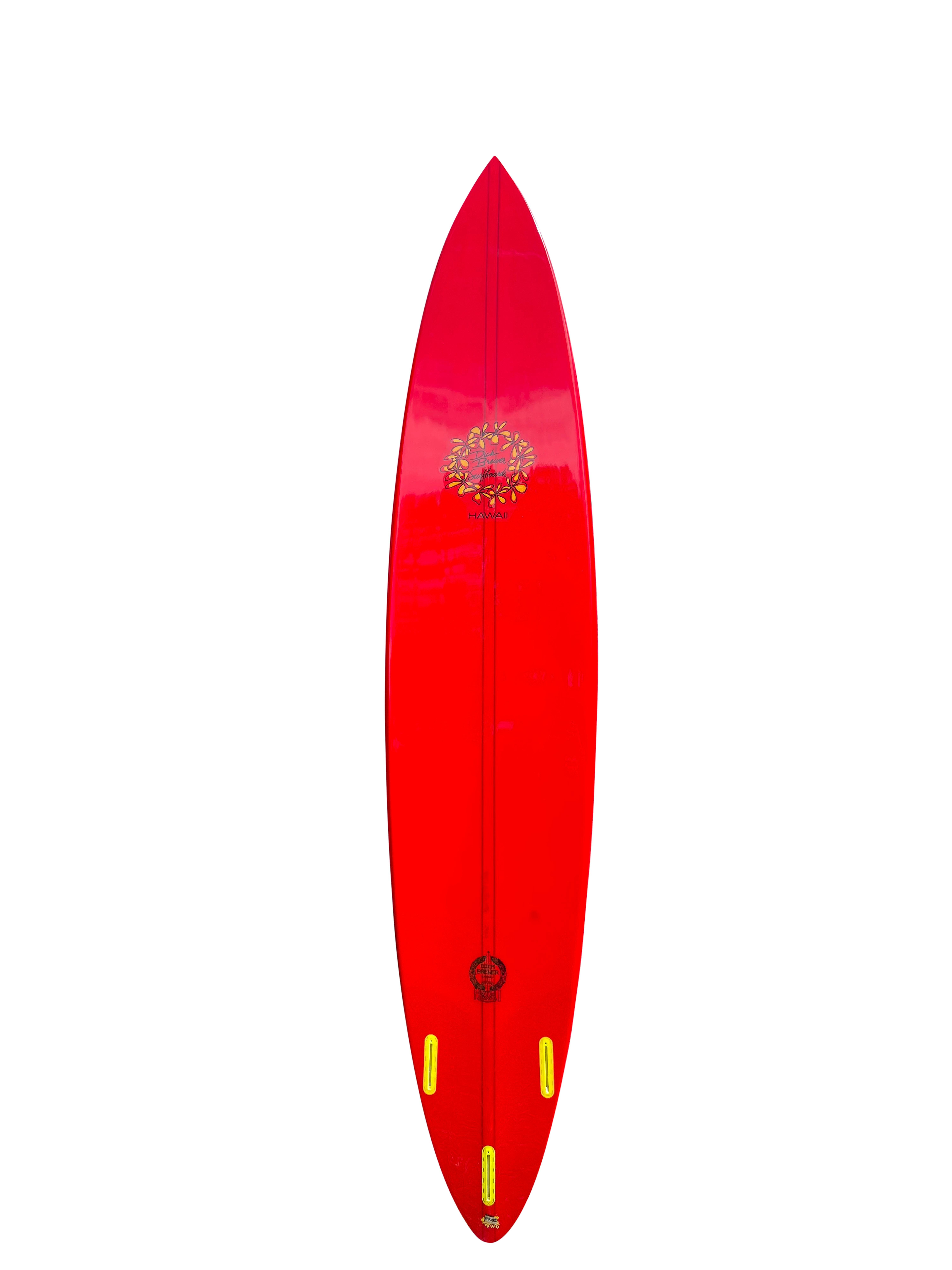 Waimea Bay Big Wave pintail surfboard made by the late Dick Brewer (1936-2022). Features beautiful red tint with vibrant yellow plumeria flower logo. Thruster (tri-fins) with redwood/balsawood T band stringer. Built to ride huge waves at the famous
