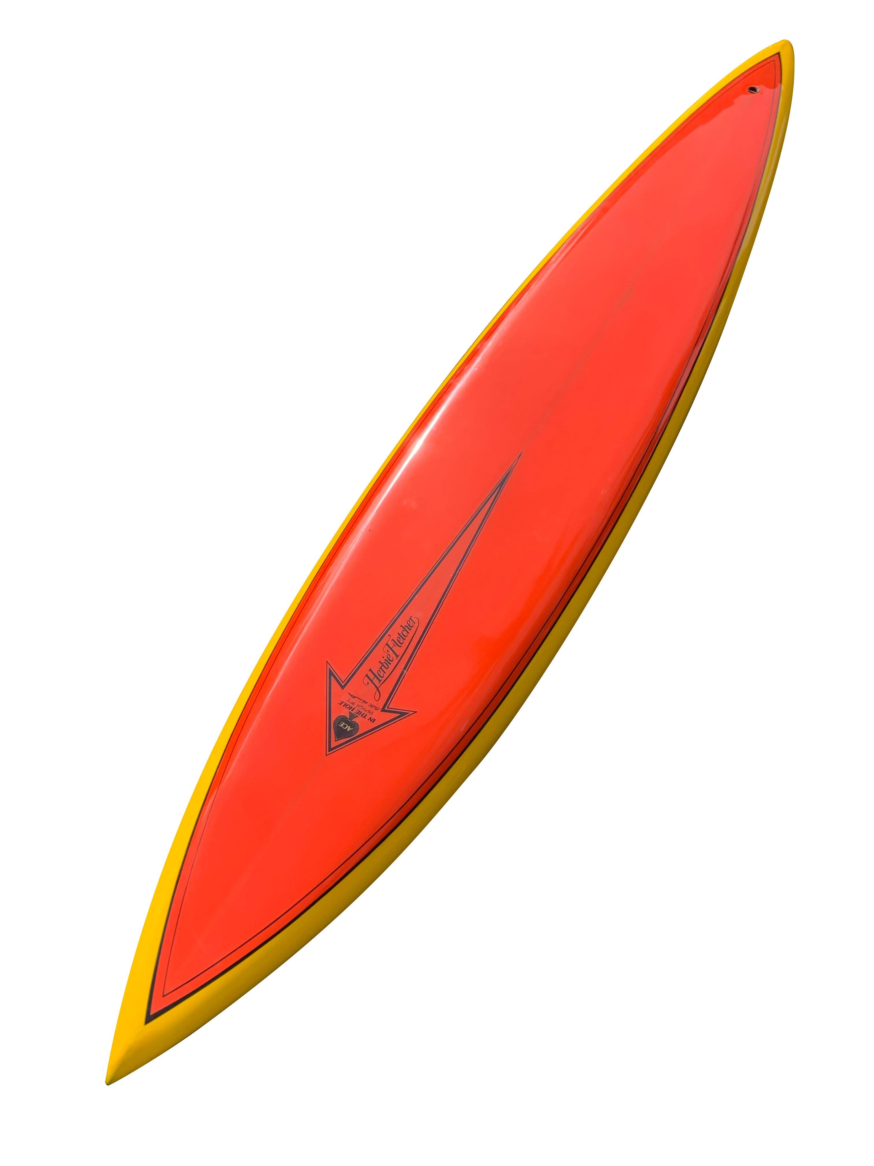 This Waimea gun is a rare piece of surfing history from a limited run late 1970’s collaboration between surfing legends Herbie Fletcher and Bill Hamilton. Features a vibrant orange deck / yellow rail wrap with black pinstripe detailing, super
