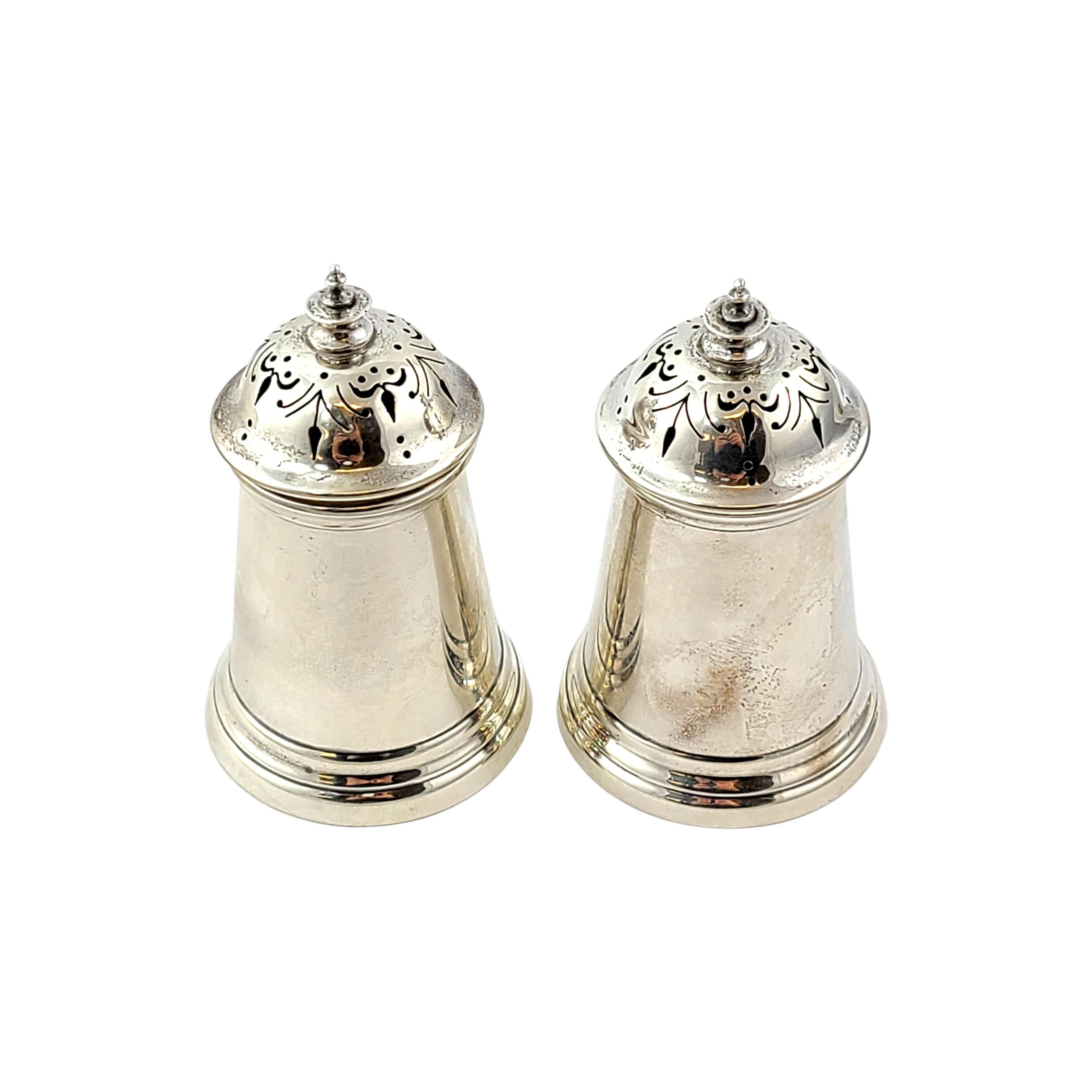 Sterling silver salt and pepper shakers by Wakely & Wheeler of London, circa 1954.

Pair of canister shaped  salt and pepper shakers with stepped base and an ornate pierced design.

Measures approx 3 1/4