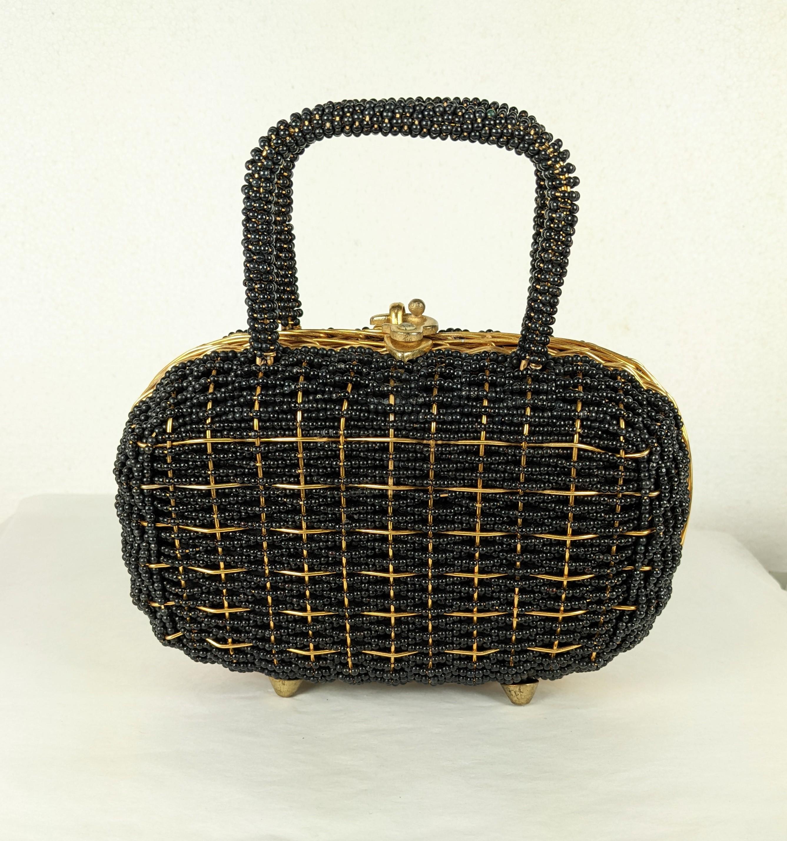 Walborg Beaded Top Handle Bag from the 1960's. Lined in gold metallic textile. Entire bag is hand beaded with black plastic beads on a hard wired frame with gilt latch on top. 1960's.  8