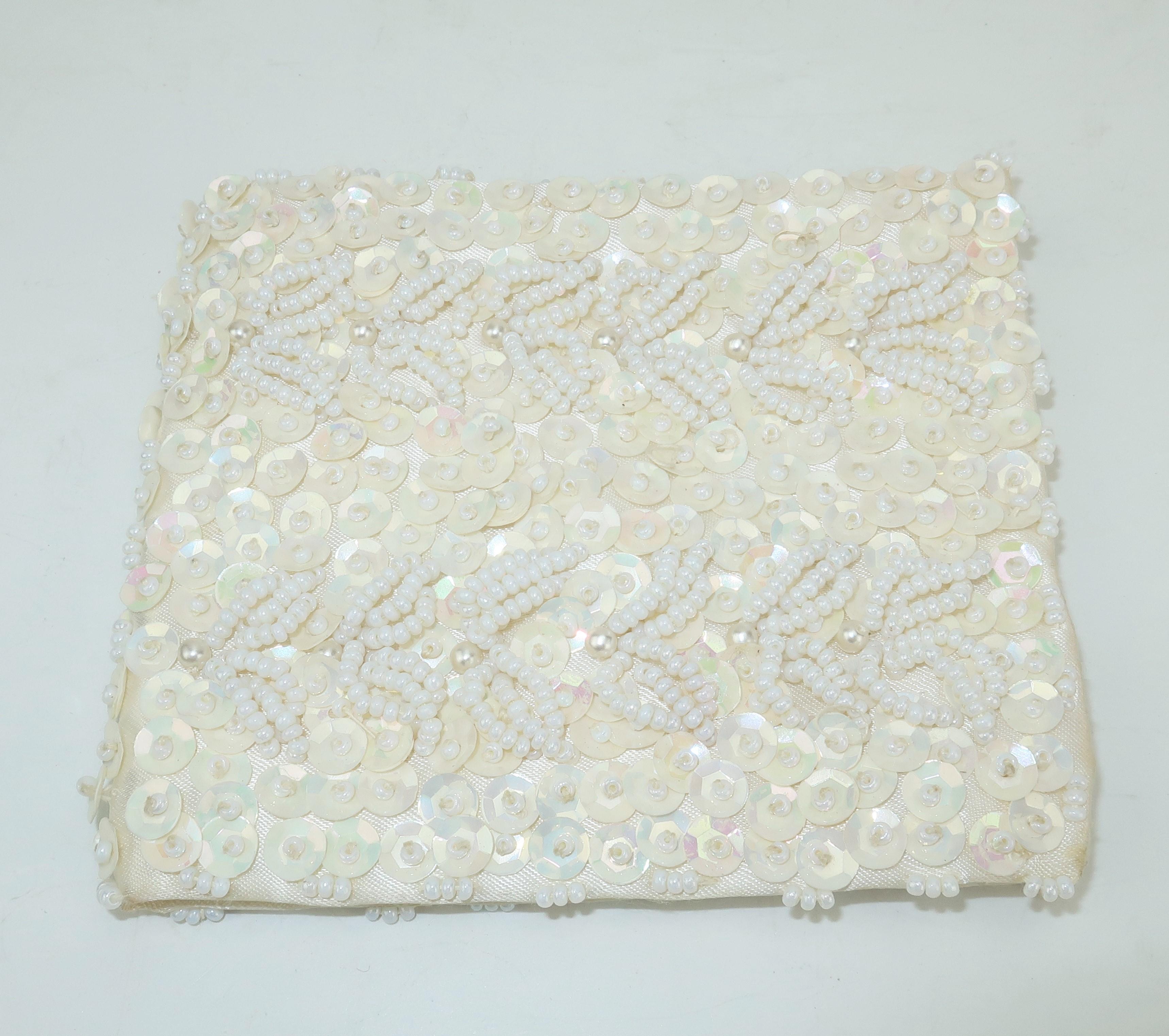 Hilde Walborg founded her company in the 1940's and was always in search of the best handmade beading for her designs.  This matching set consists of an evening wallet and glasses case fully embellished with white seed beads and sequins in a floral