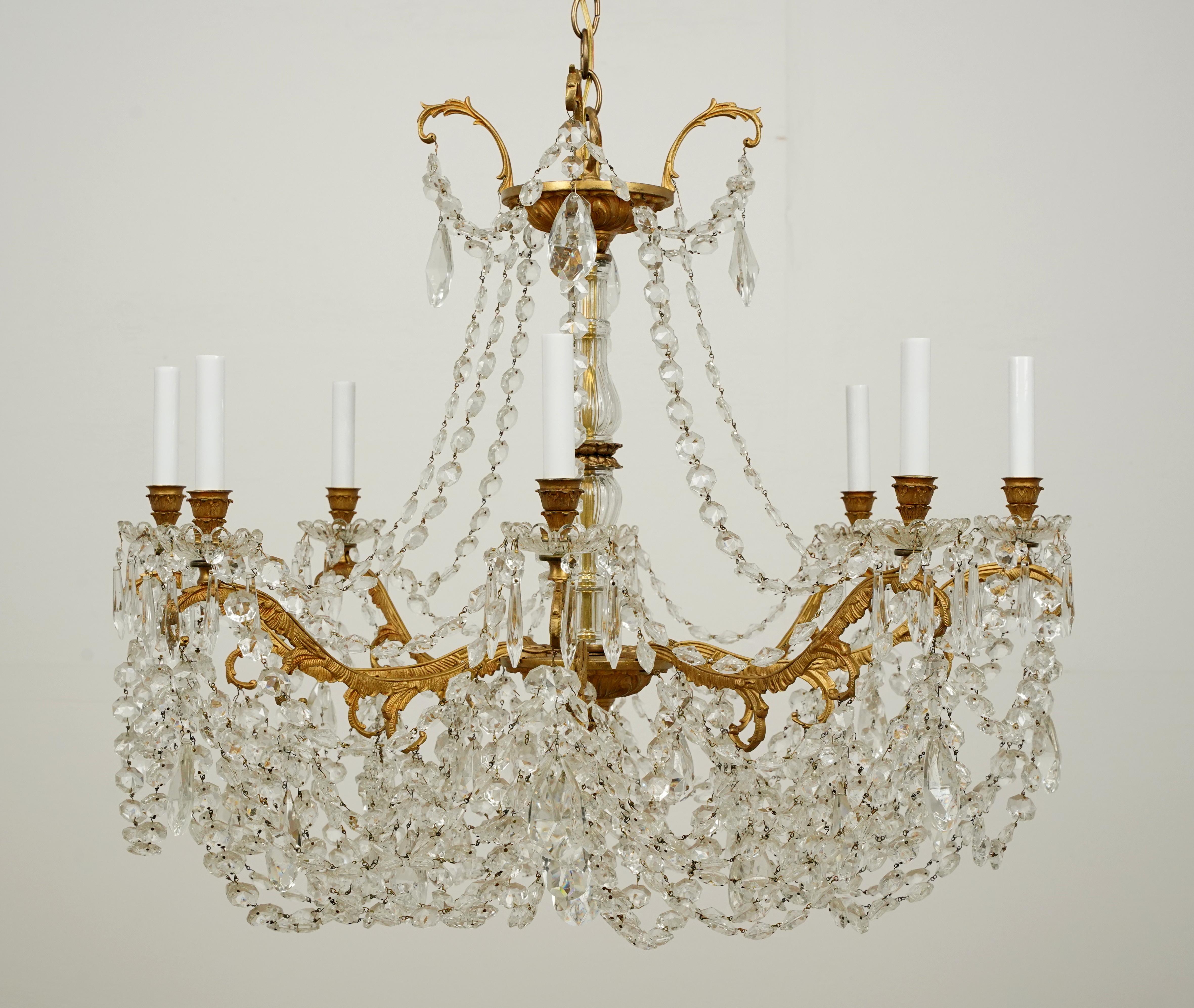 Elegant crystal and brass chandelier with eight candlestick arms from the 32nd floor of the Waldorf Astoria towers in Suite 32M2. The frame in an ornate French style is made of brass with a gilt finish. The crystals are in a faceted octagon,