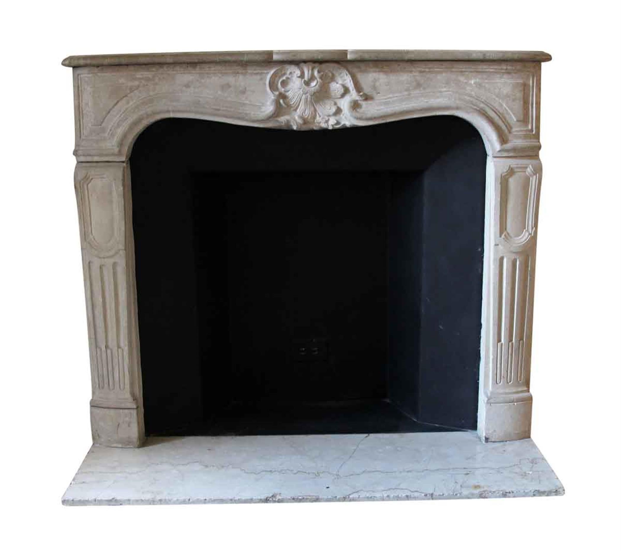 This solid limestone mantel was imported from France and installed in the Waldorf Astoria hotel in the 1930s when the hotel was first build on Park Avenue in New York City. It has light tan coloring with decorative hand-carved details. This