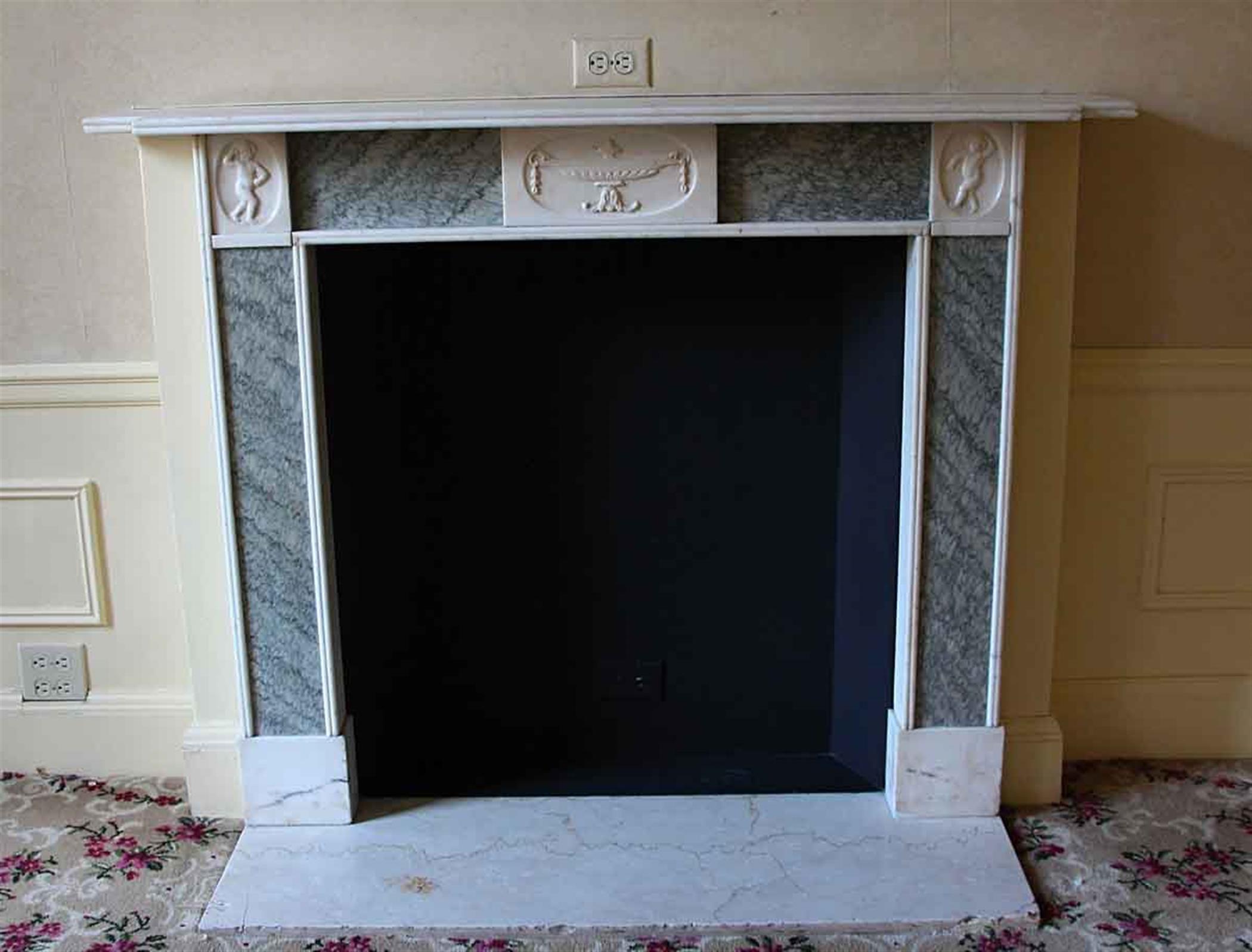 Hearth nor included. Imported from France and installed at the 1931 NYC Waldorf Astoria Hotel on Park Ave. Original to suite 15V of the hotel. 19th century petite Georgian style statuary white and green marble mantel featuring cherubs on the top two